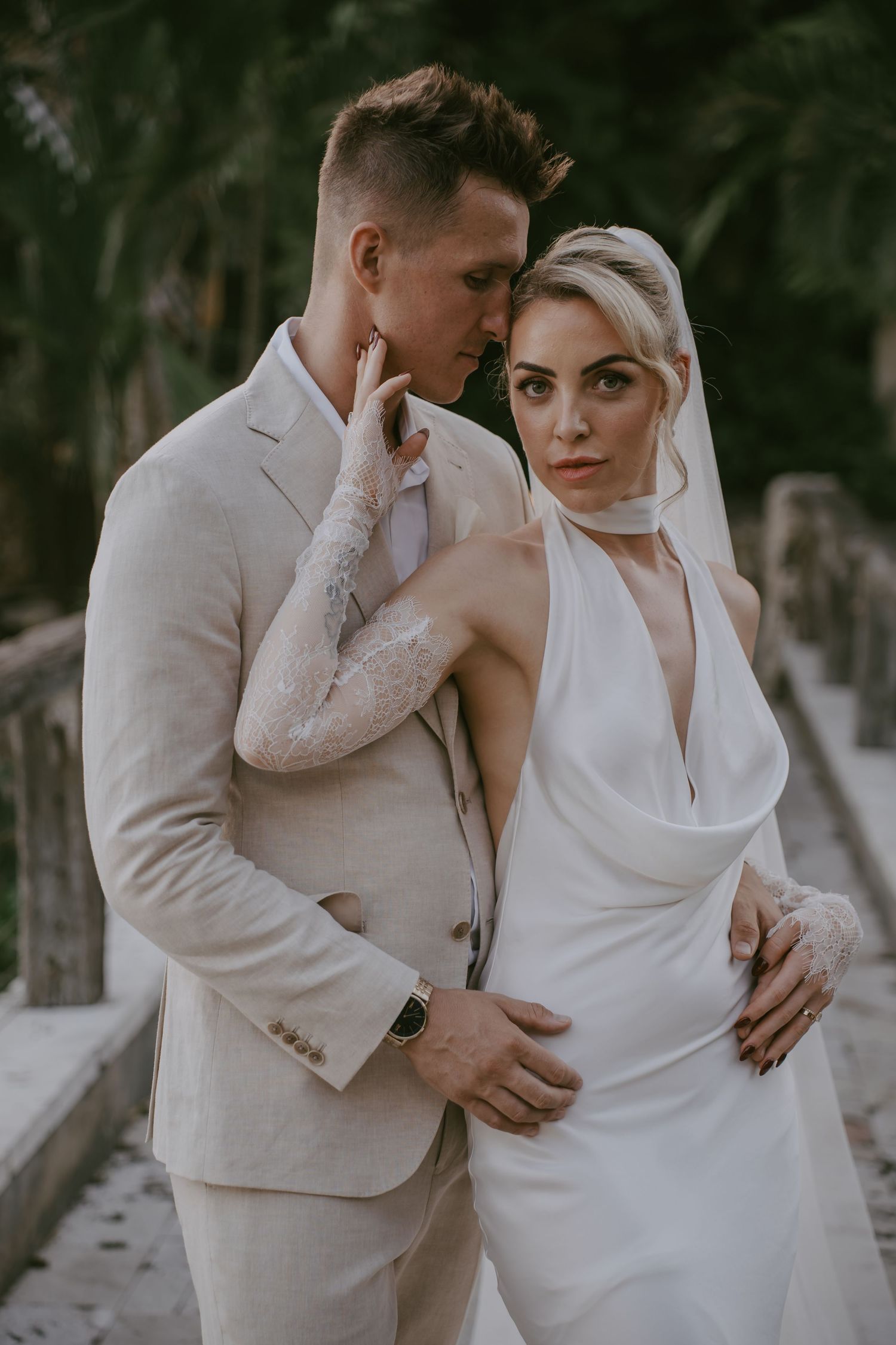 Intimate wedding couple moment captured against a light background.