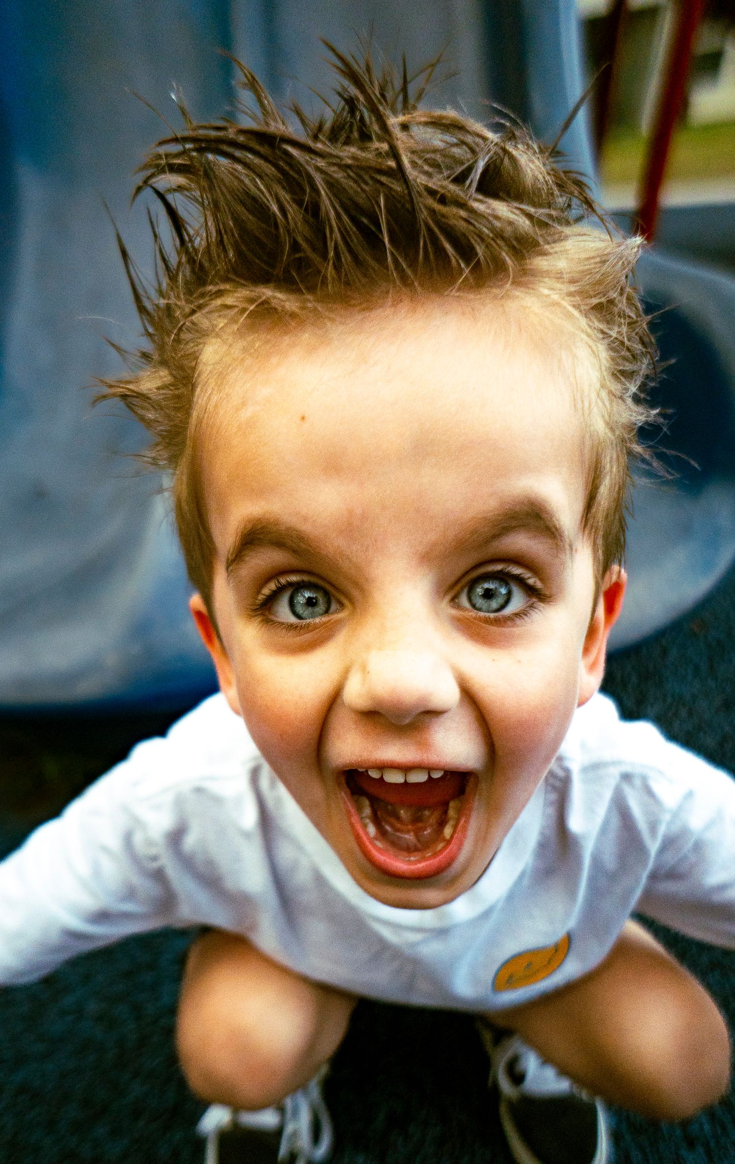 A young boy yelling happily in a fisheye lens