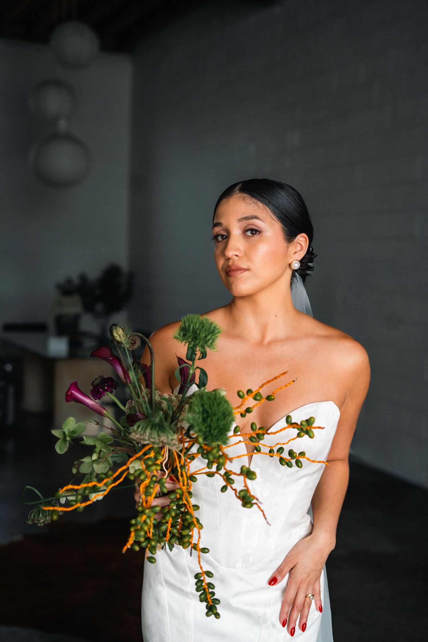 A bride holding an eclectic bunch of flowers.
