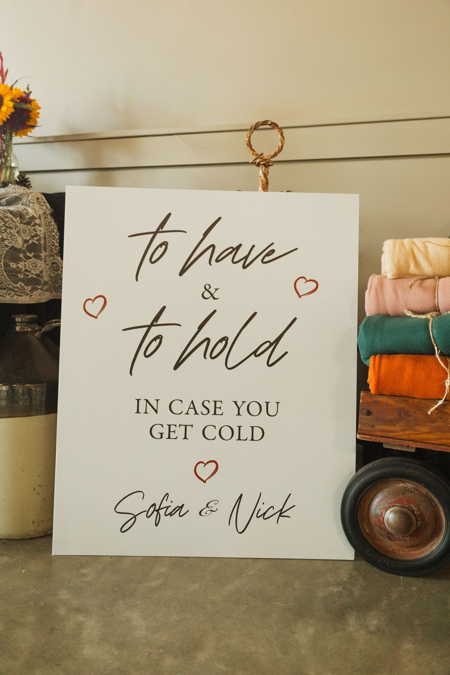 Wedding signage displaying 'To Have and To Hold' and other romantic phrases in calligraphy with heart decorations.