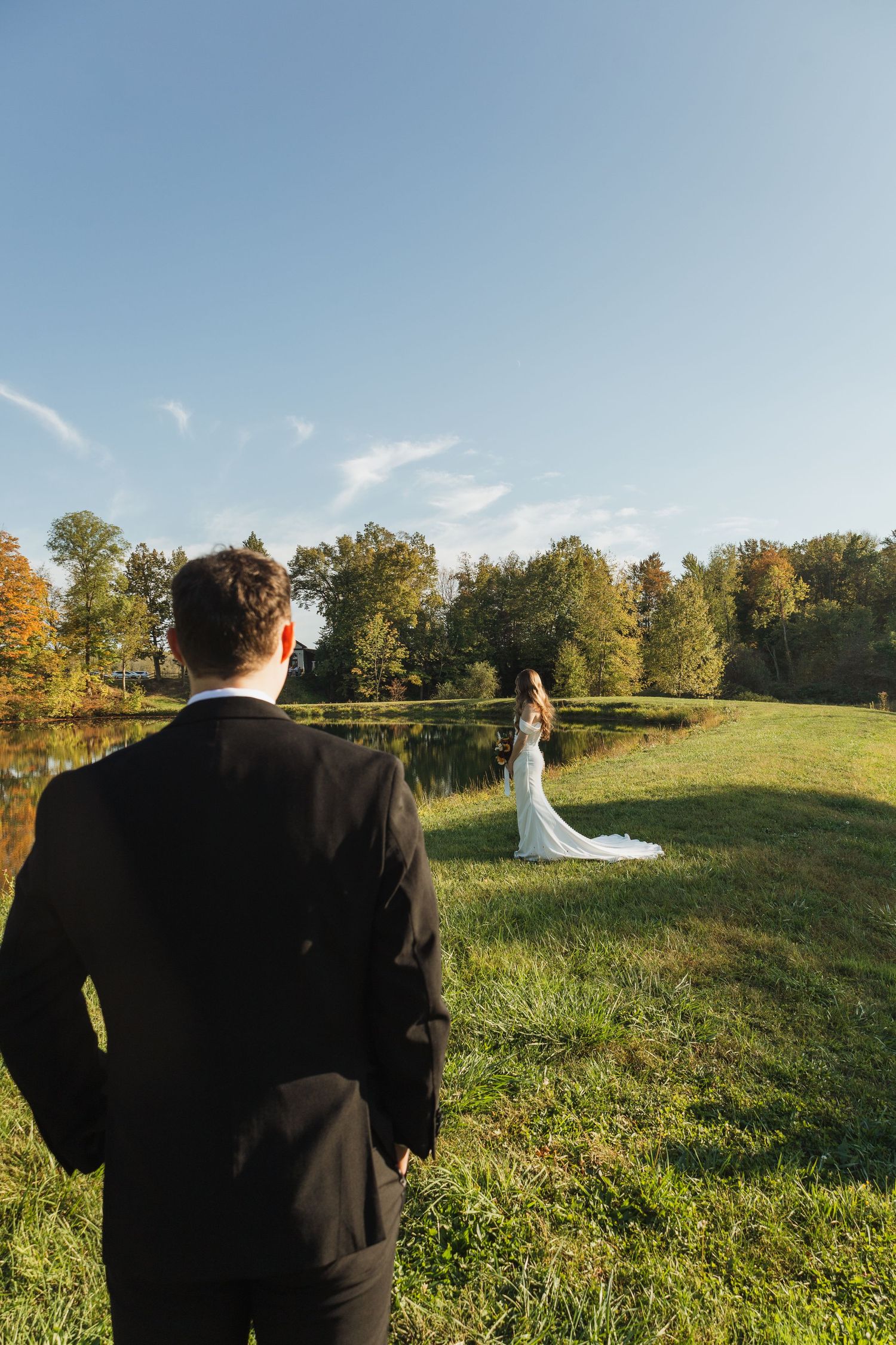 Outdoor wedding first look sequence showing couple in grassy field during golden hour.