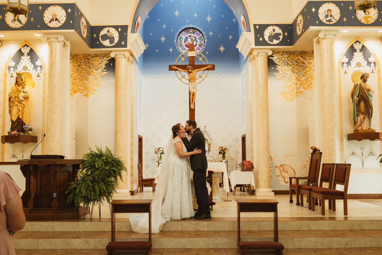 Wedding ceremony in a church with blue domed ceiling and ornate religious decor.