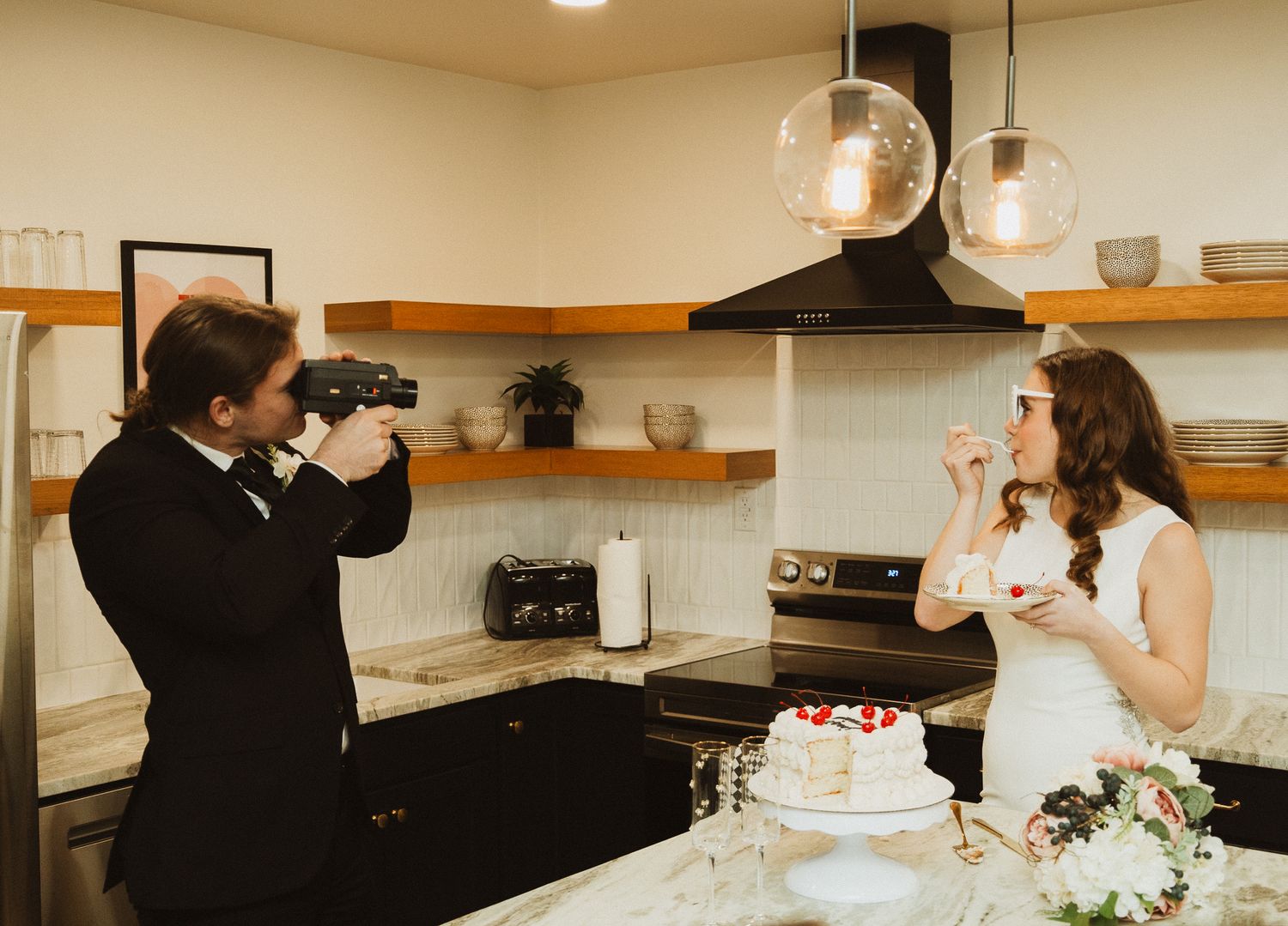 A couple playfully takes photos of each other while celebrating with wedding cake.