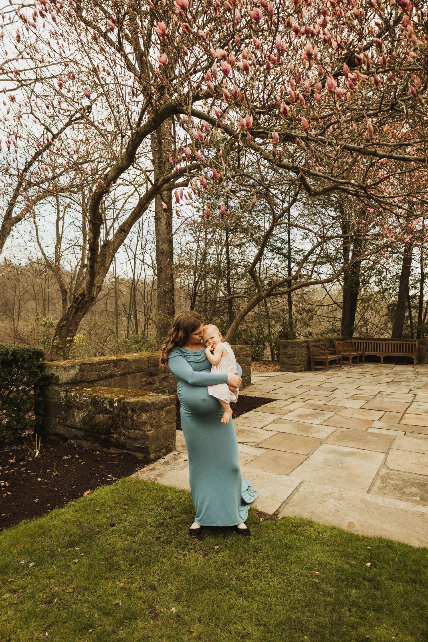 A tender moment captured on a stone patio surrounded by autumn trees with red leaves.