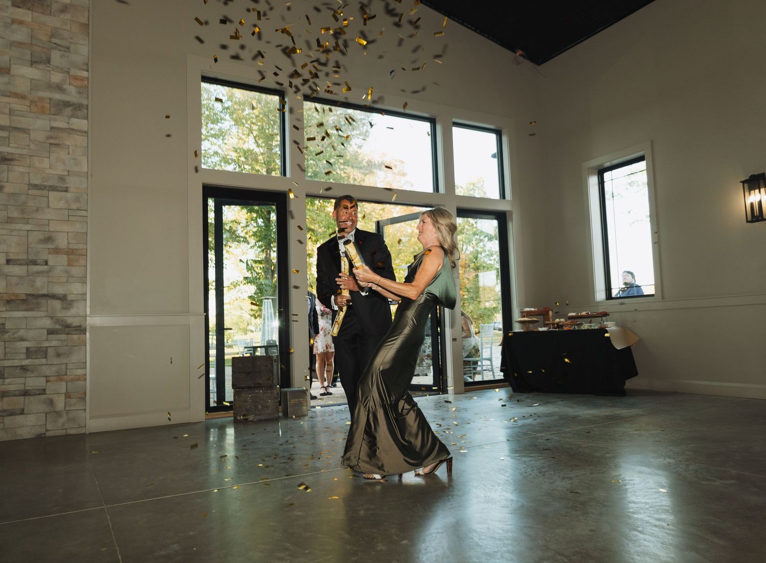 A couple shares their first dance in an elegant modern venue with large windows and natural light.