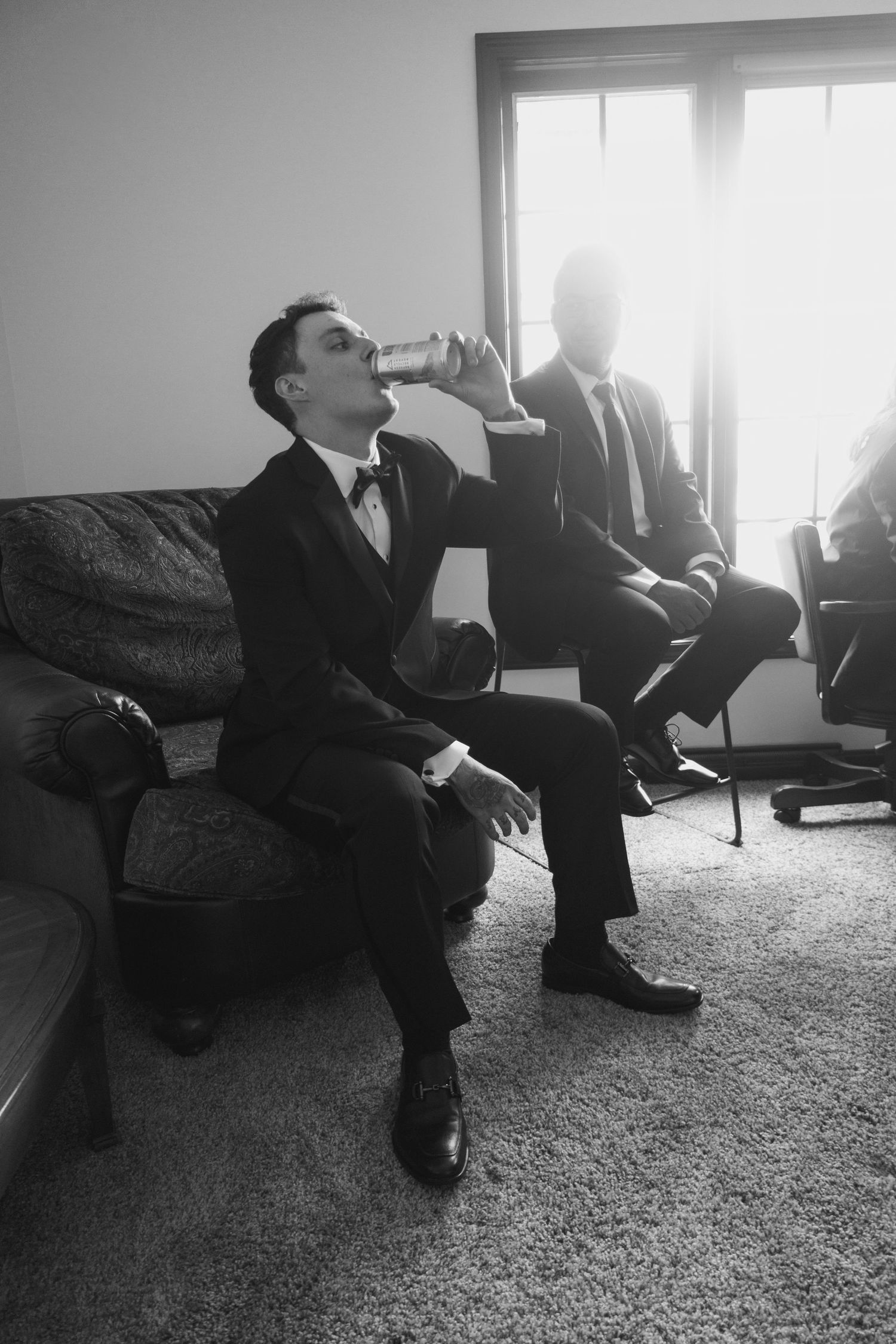 Black and white photos of groomsmen relaxing and having drinks before the ceremony.