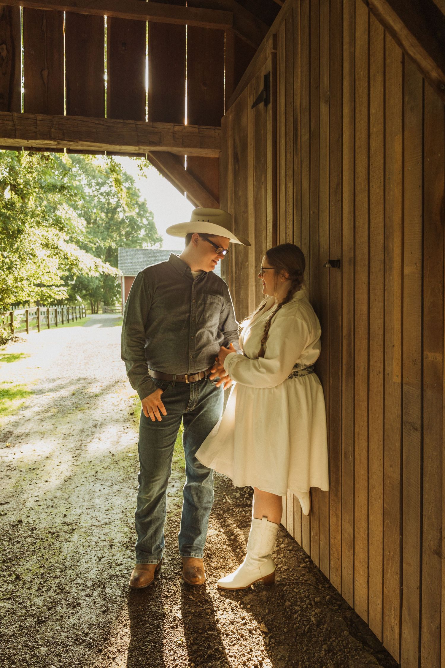 Romantic scene inside a rustic wooden barn with sunlight streaming through the doorway.
