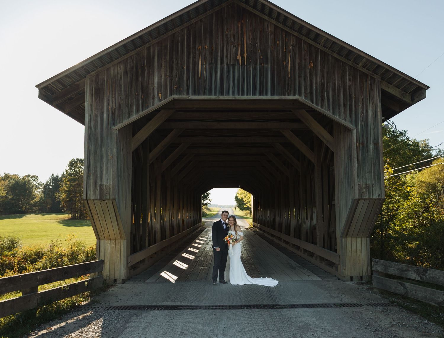 Rustic wooden covered bridge venue with natural lighting and countryside views.