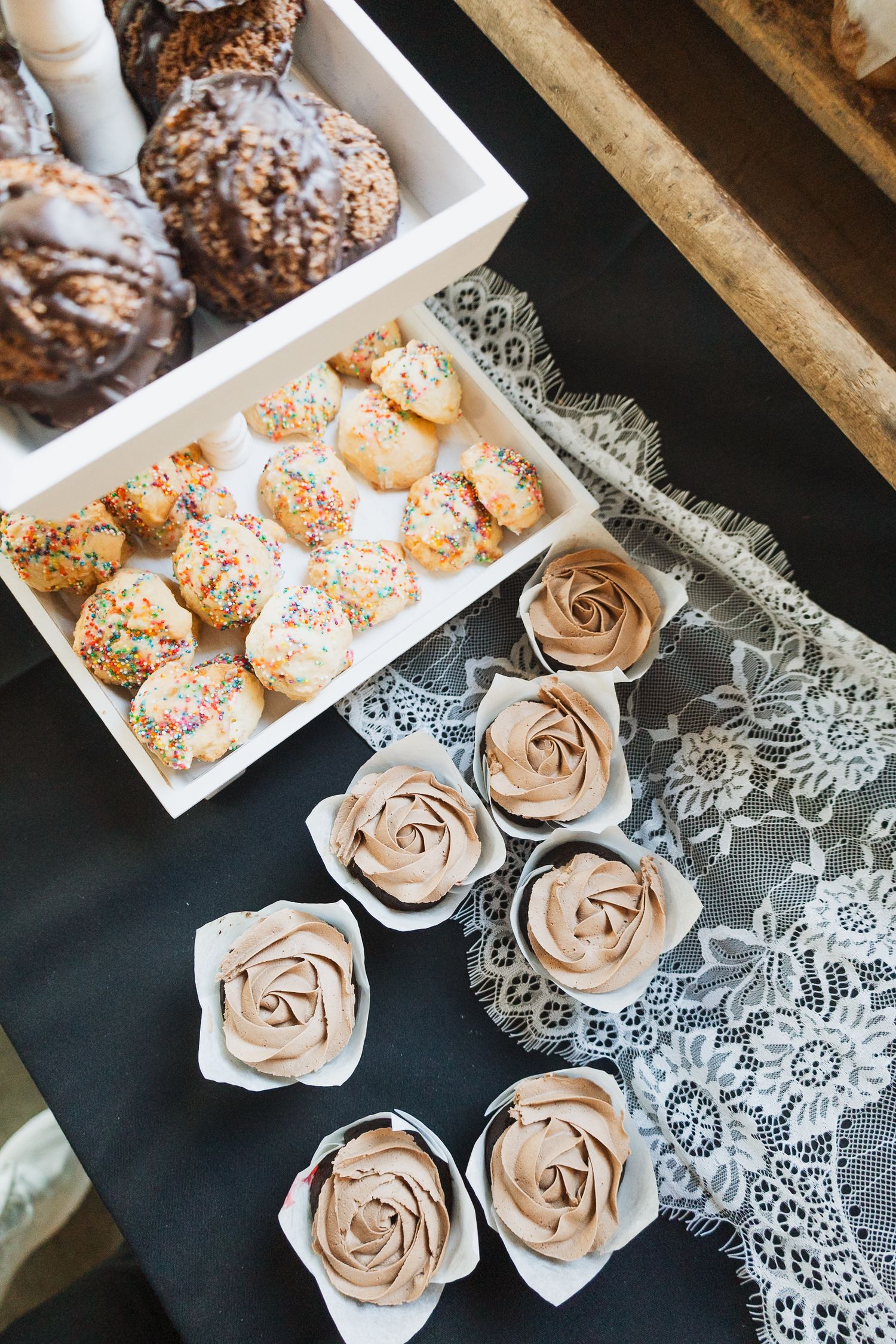 Elegant rose-shaped desserts arranged on white serving trays with delicate lace accents.