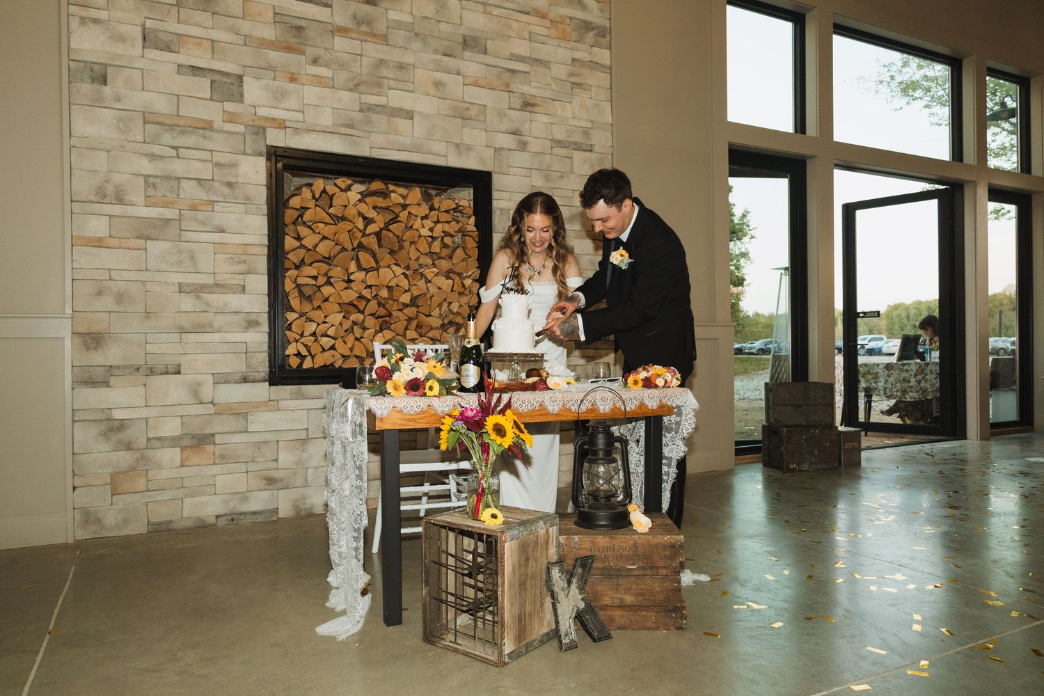 A modern rustic interior with stone walls and wooden accents features natural light streaming through large windows.
