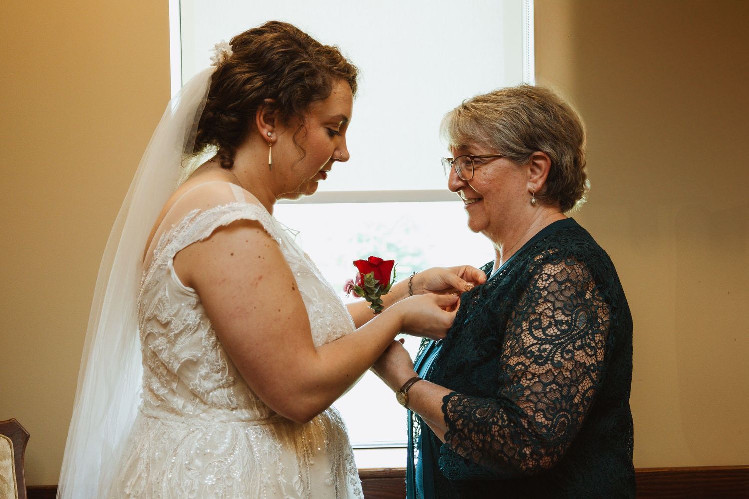 Emotional moment shared between people during wedding preparations in a warmly lit room.