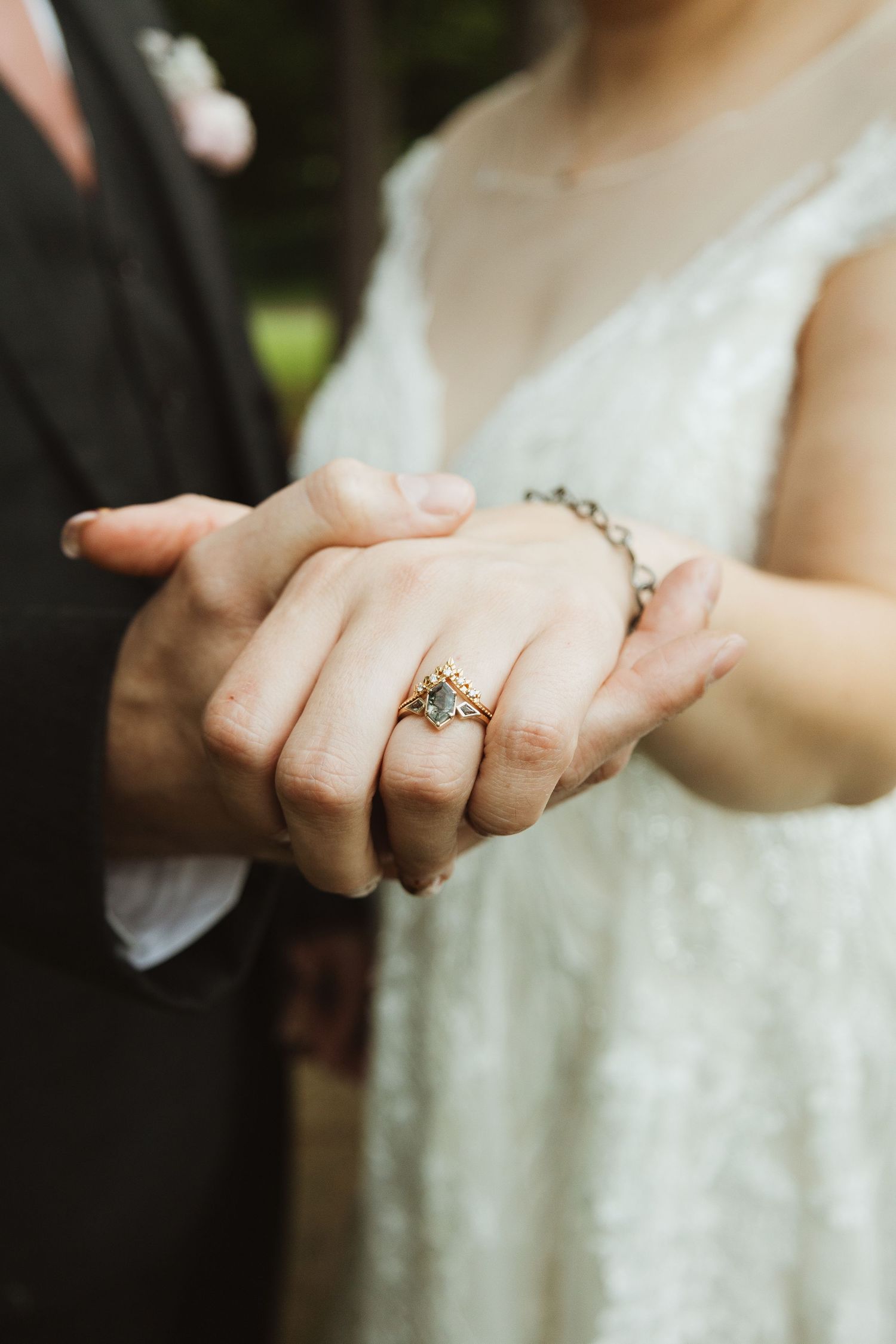 Close-up shots of hands displaying an elegant engagement ring with natural lighting.