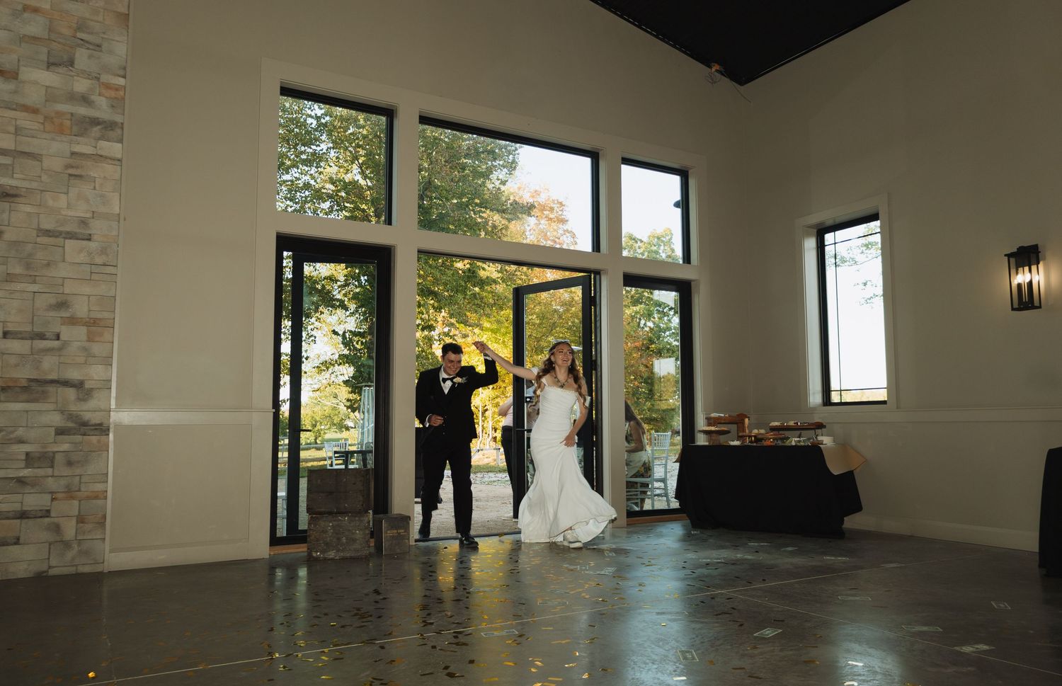 Interior panorama of a modern event venue with stone accent walls and large windows letting in natural light.
