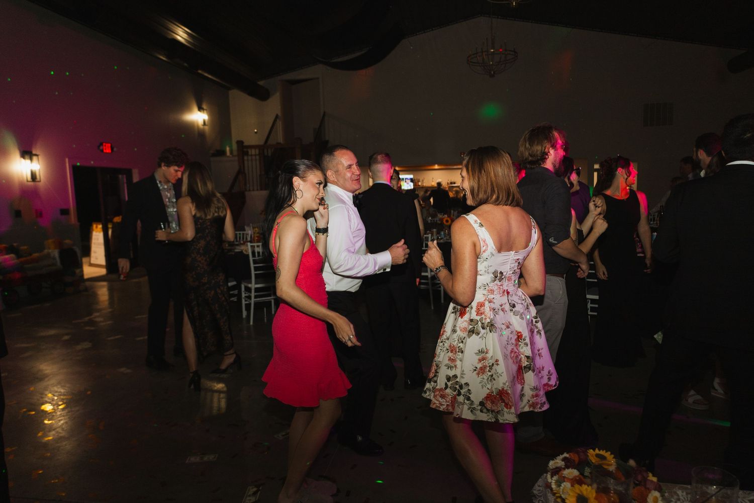 Guests enjoying themselves on a dark dance floor at an evening wedding reception.