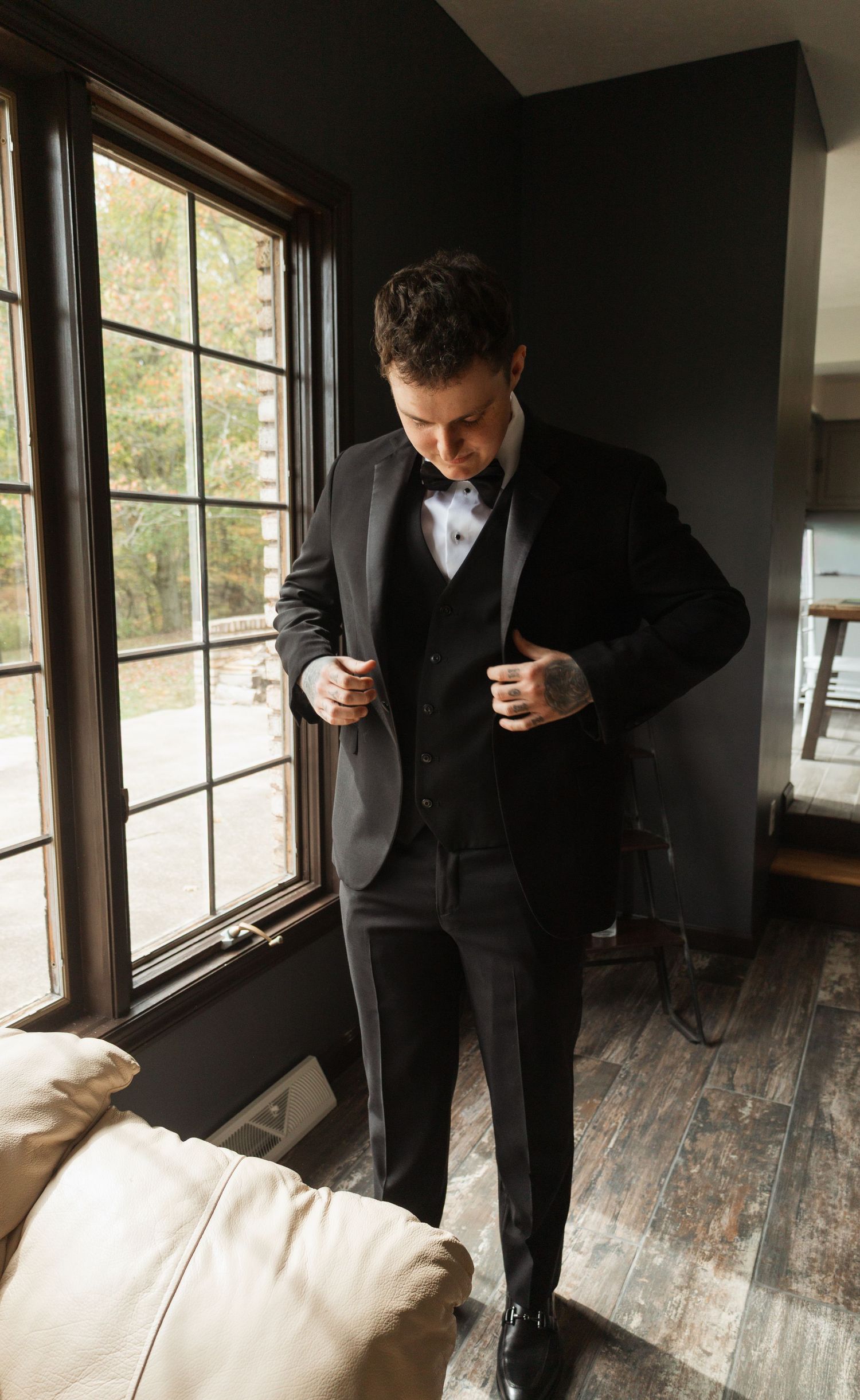 Sequence of photos showing person in dark suit looking down at something in a room with wooden floors and windows.