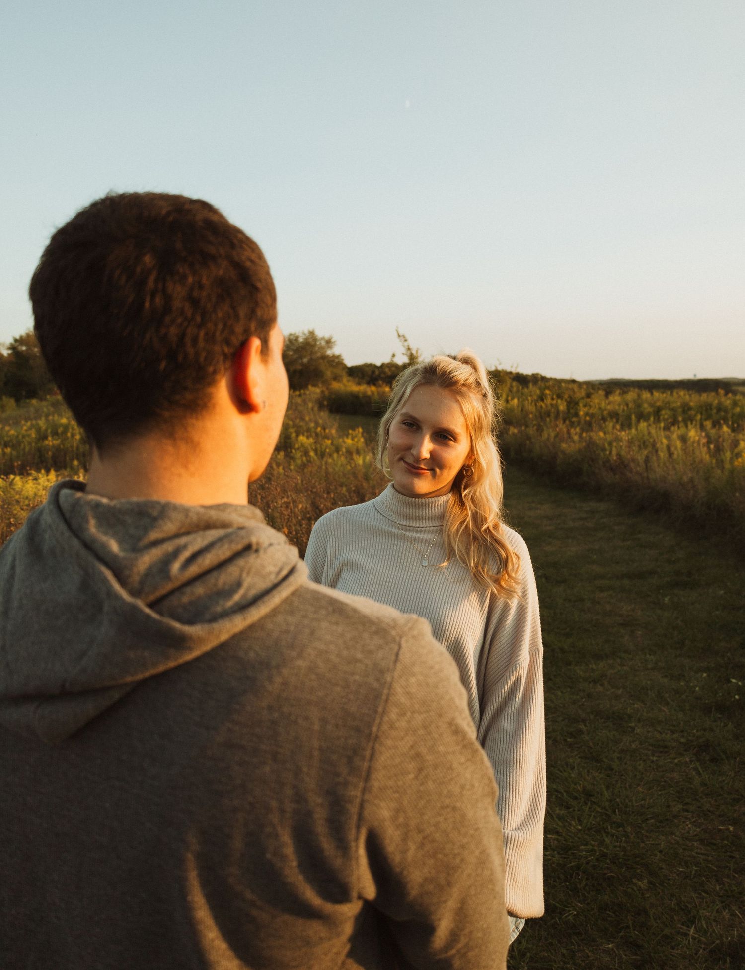 Casual couple having conversation in outdoor setting during sunset.