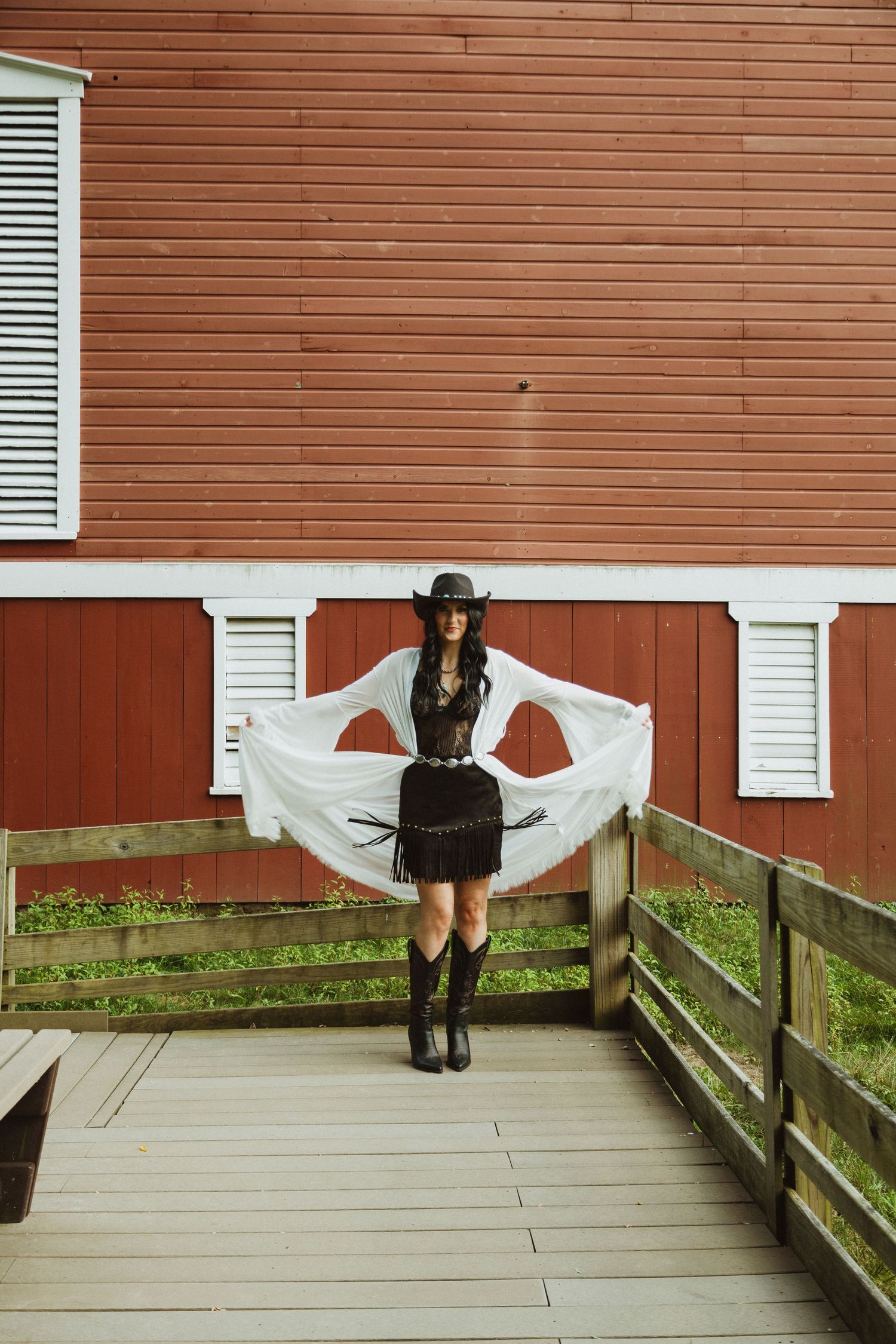 A creative photo series showing movement and flowing fabric against a rustic red barn backdrop on a wooden deck.
