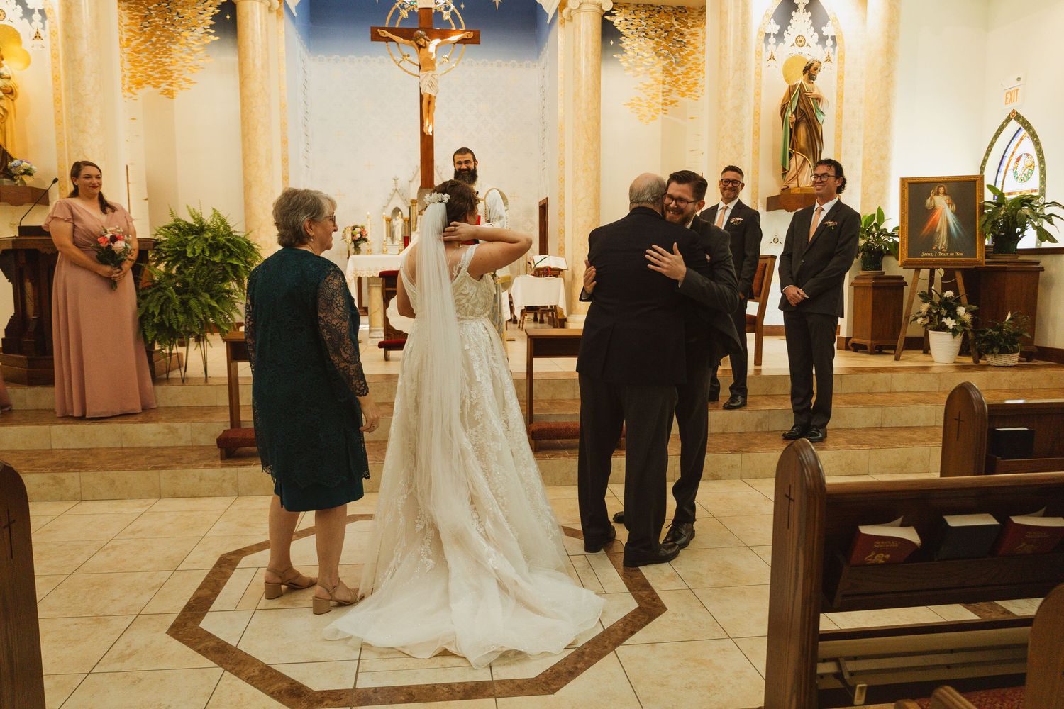 Wedding ceremony taking place in an elegant church interior with ornate golden decor and white columns.