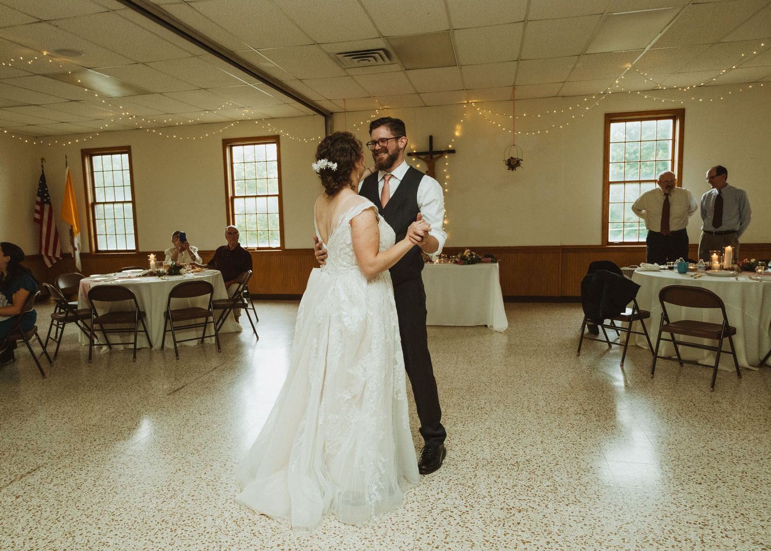 Elegant wedding reception hall with folding chairs and natural light streaming through windows.