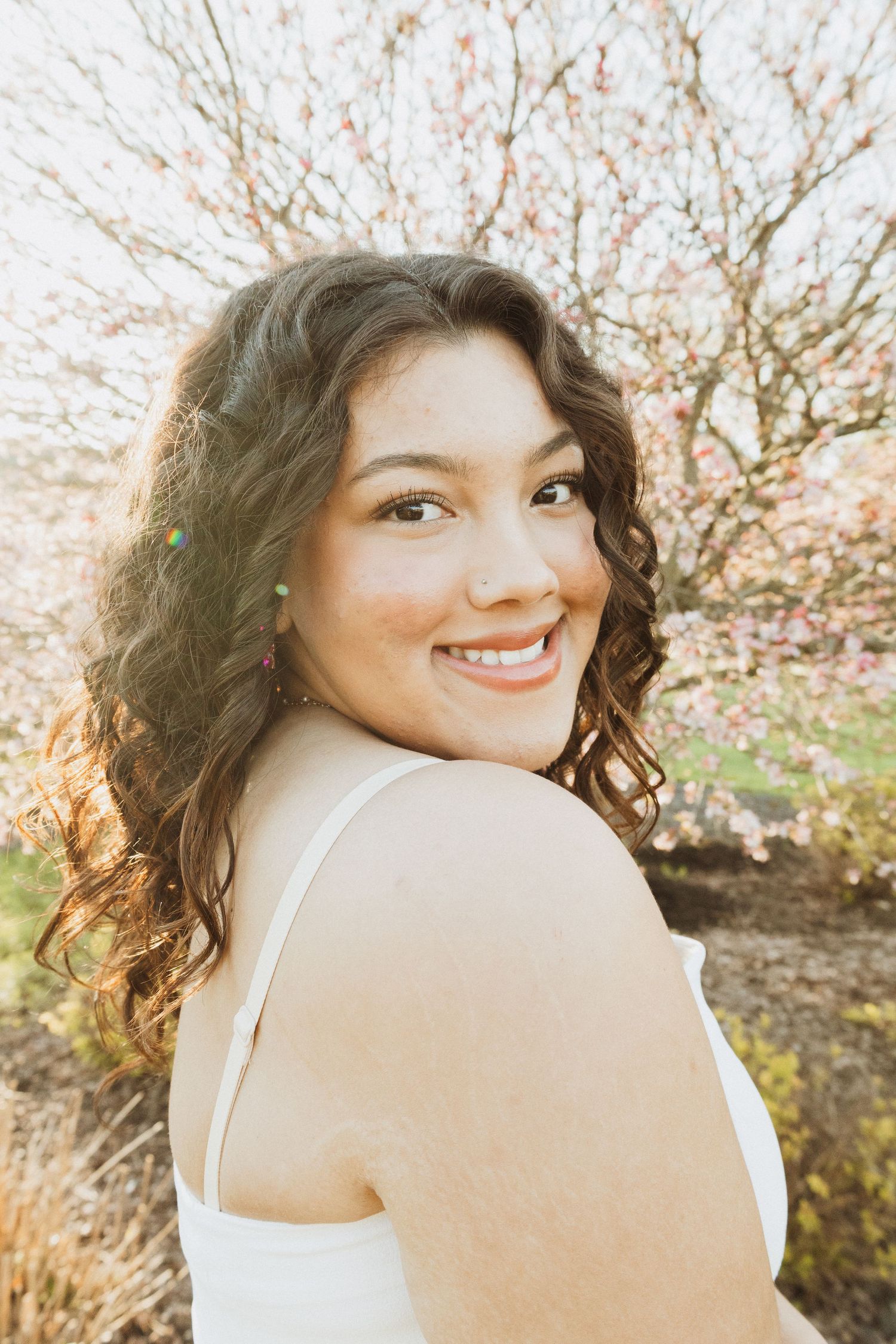 Springtime portrait with blooming cherry blossoms in warm golden sunlight.