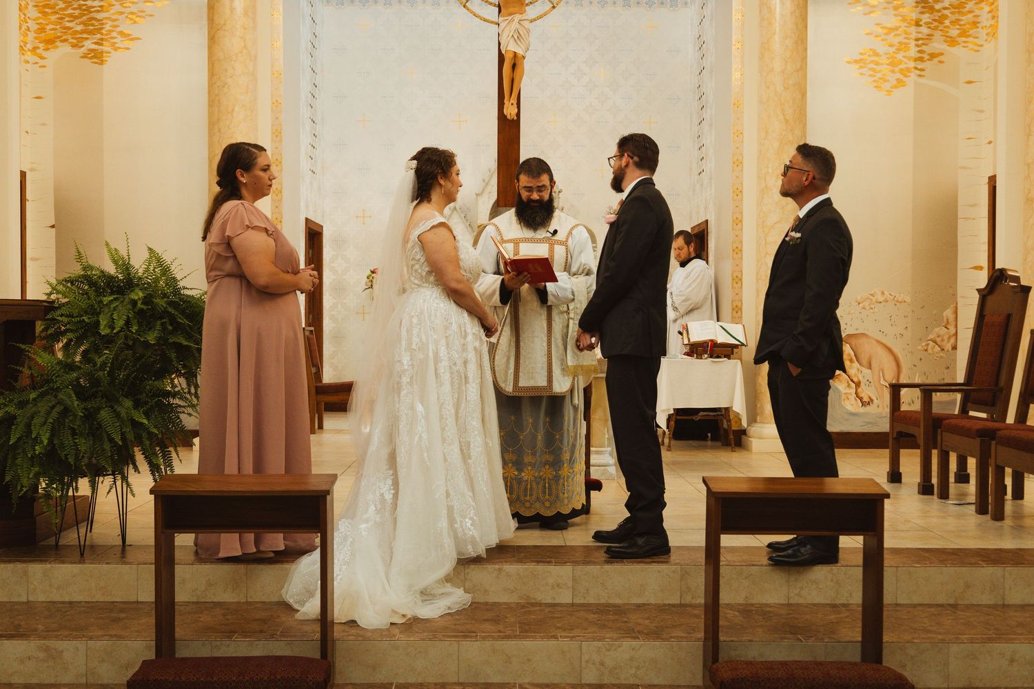 Wedding ceremony in progress inside a traditional church with warm lighting and wooden pews.
