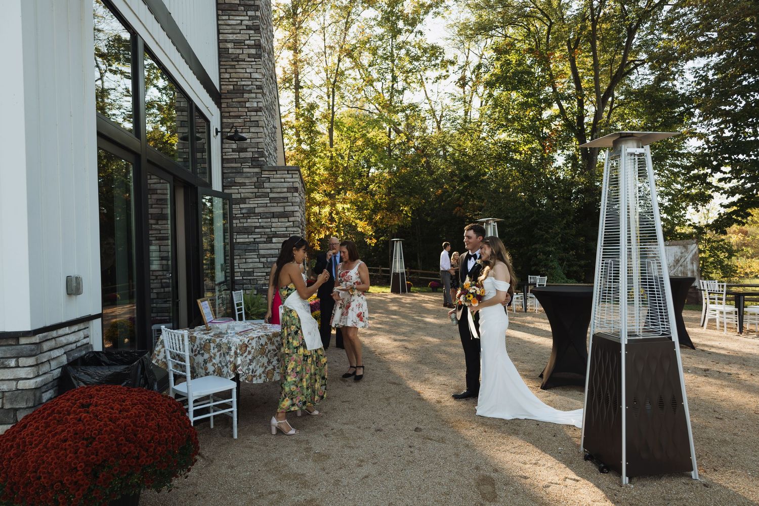 Stone pillars and pathways frame an elegant outdoor wedding venue at sunset.