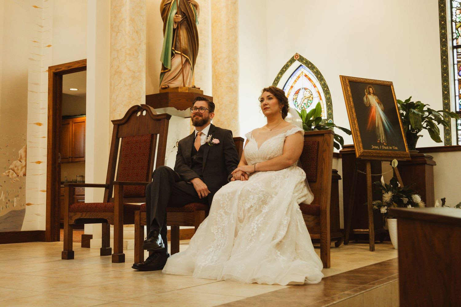 A traditional church wedding ceremony with wooden pews and decorative altar space.
