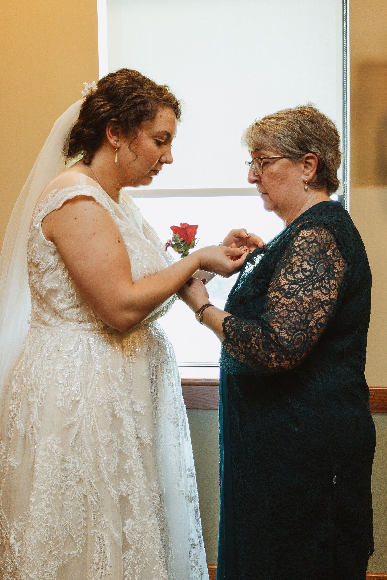 A series of photos showing someone in a white wedding dress being helped with final preparations by another in black lace.