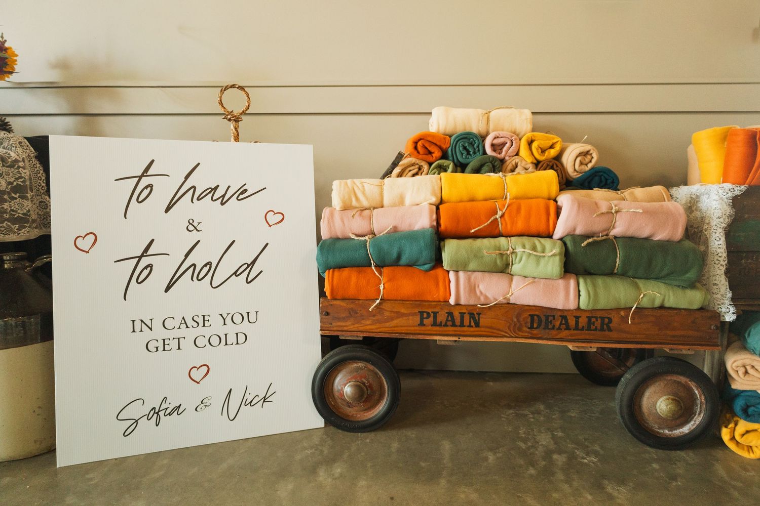 Wedding decor display featuring rustic signs and orange fall-themed decorative elements.