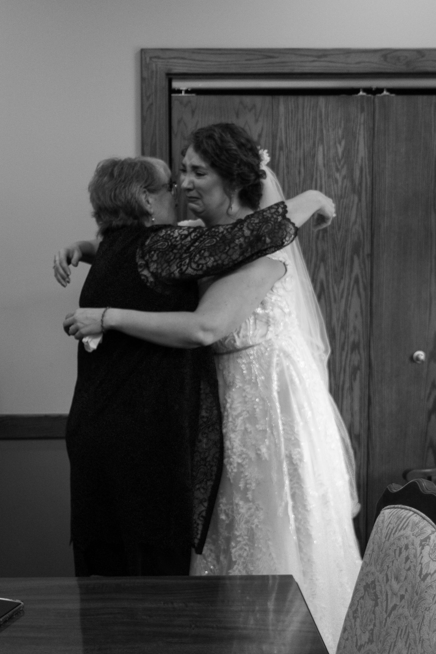 Emotional black and white moment captured during wedding reception.