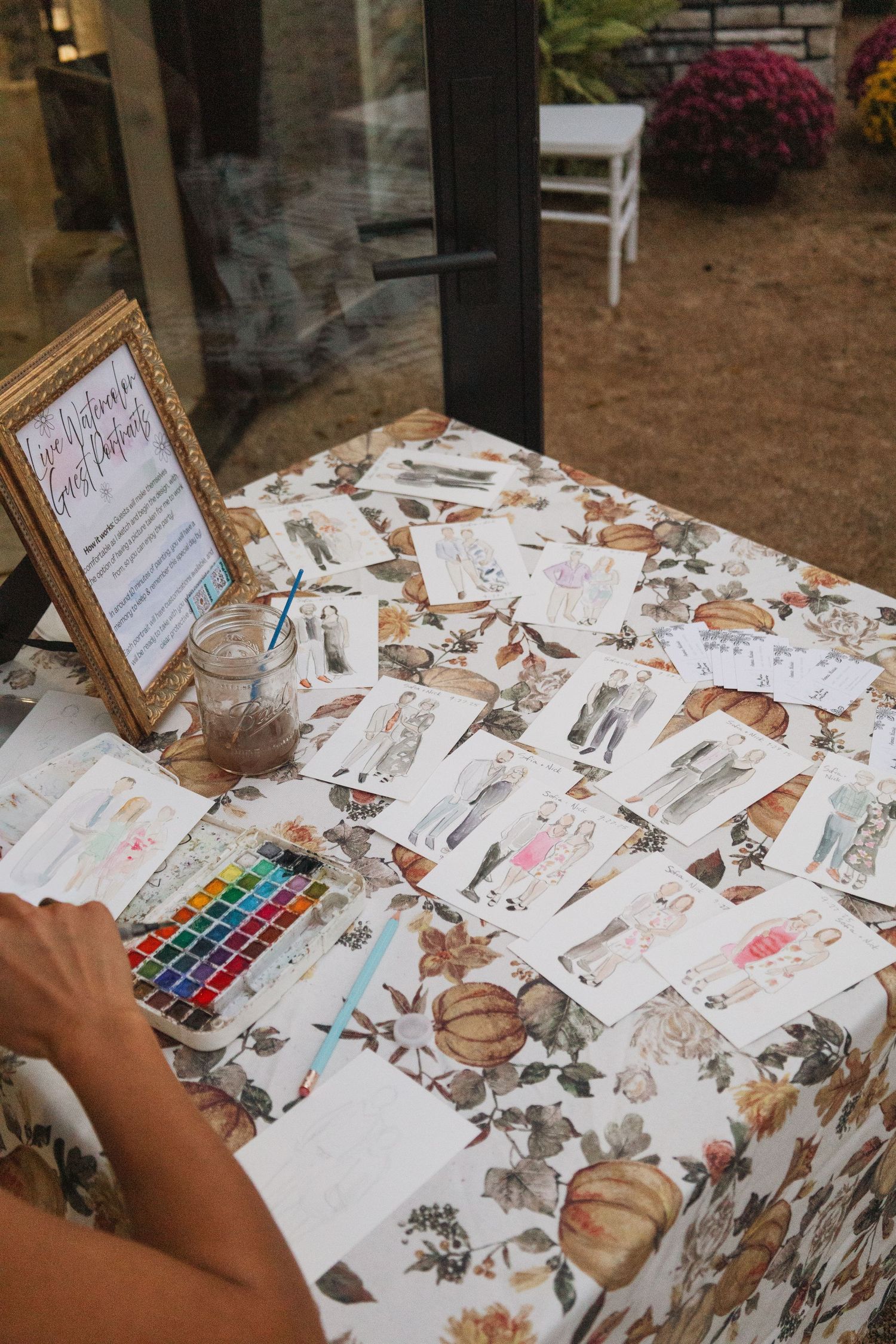 Wedding guest book table decorated with floral patterns and watercolor paint set.