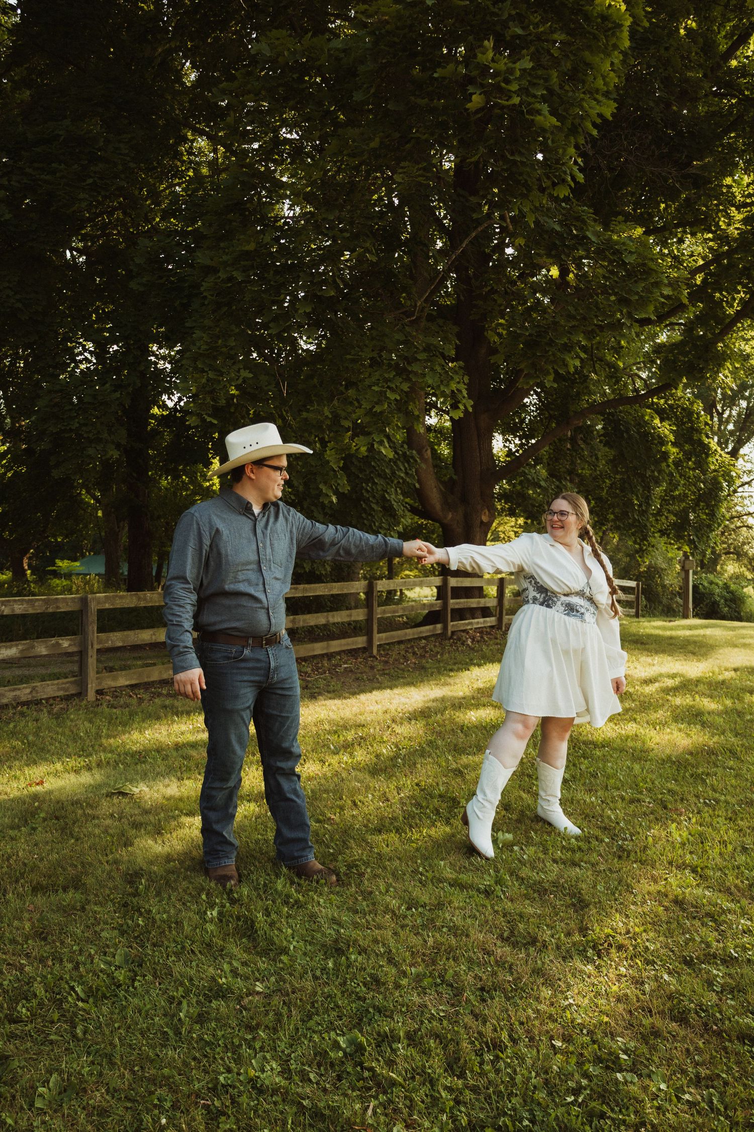 A series of playful dance poses shown against a rustic wooden fence and grassy hillside on a sunny day.