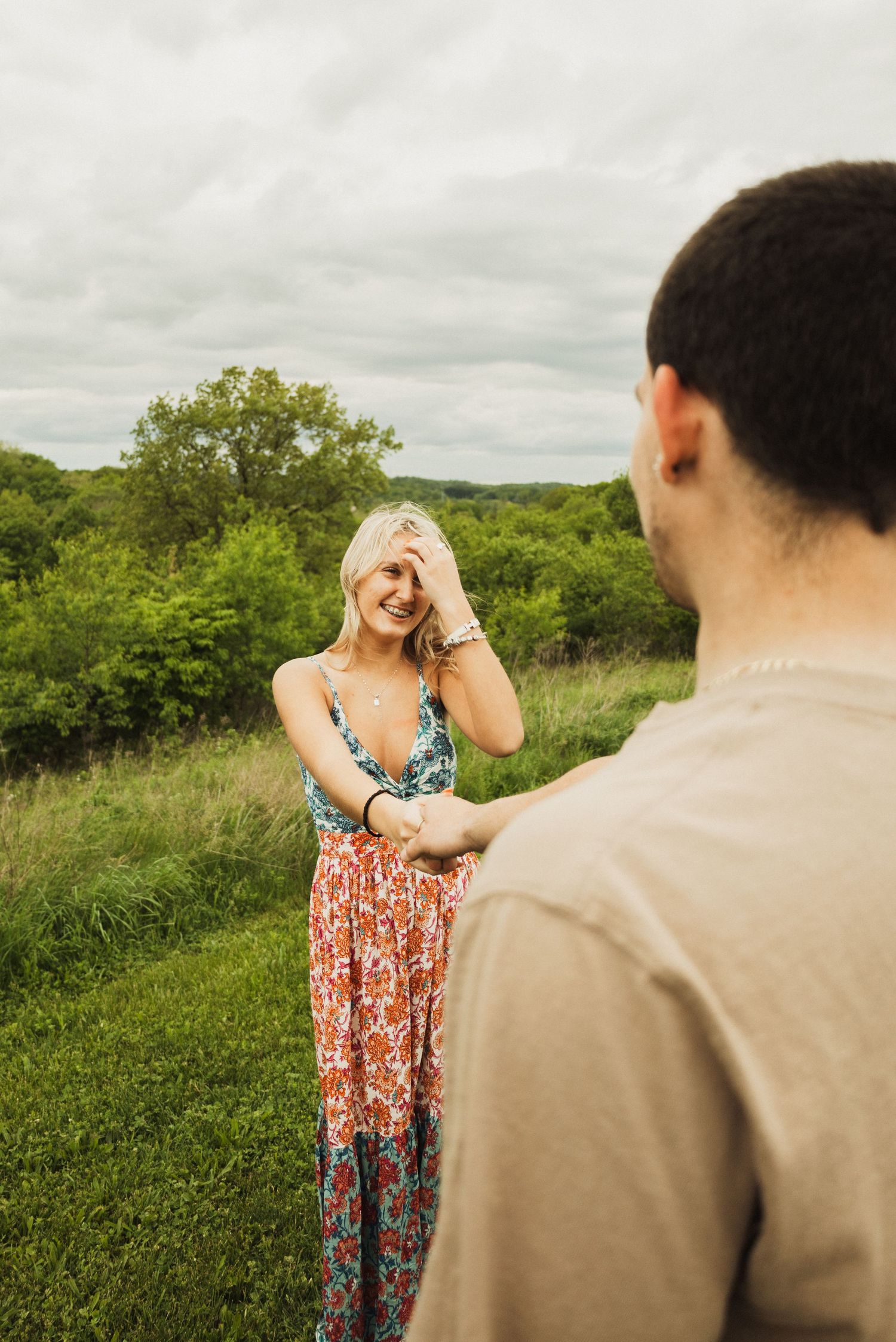 A playful outdoor photoshoot showing a couple sharing a lighthearted moment in nature.