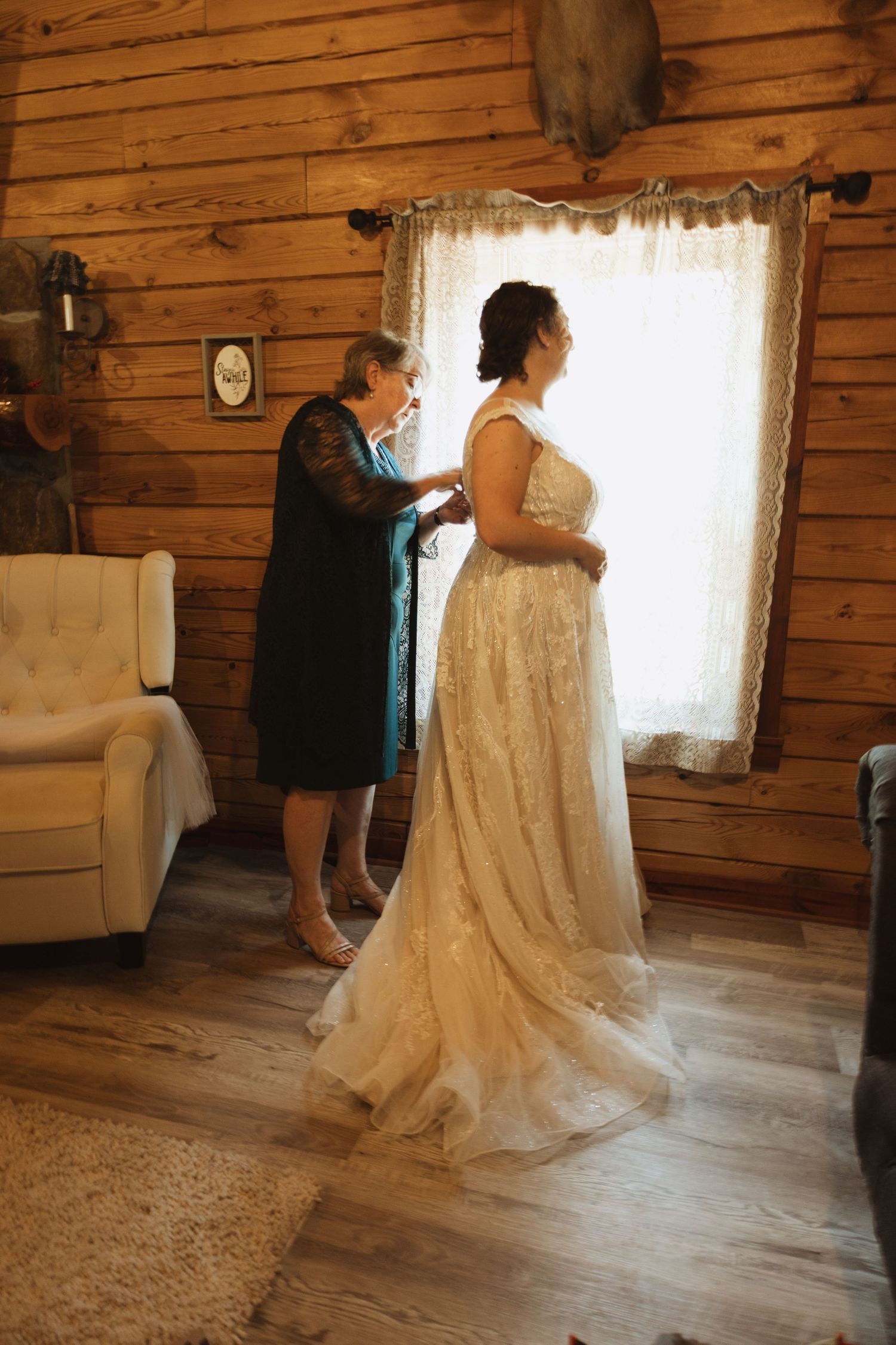 Wedding preparations taking place inside a rustic wooden cabin with natural lighting.