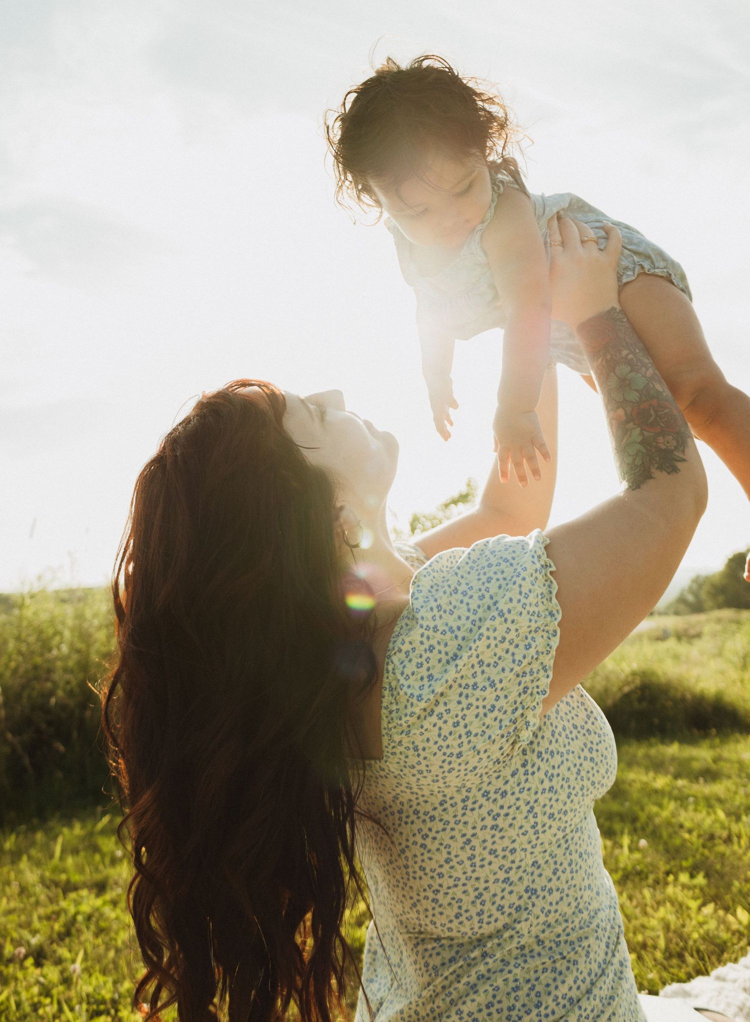 A joyful outdoor scene of carefree interaction between parent and child during golden hour.
