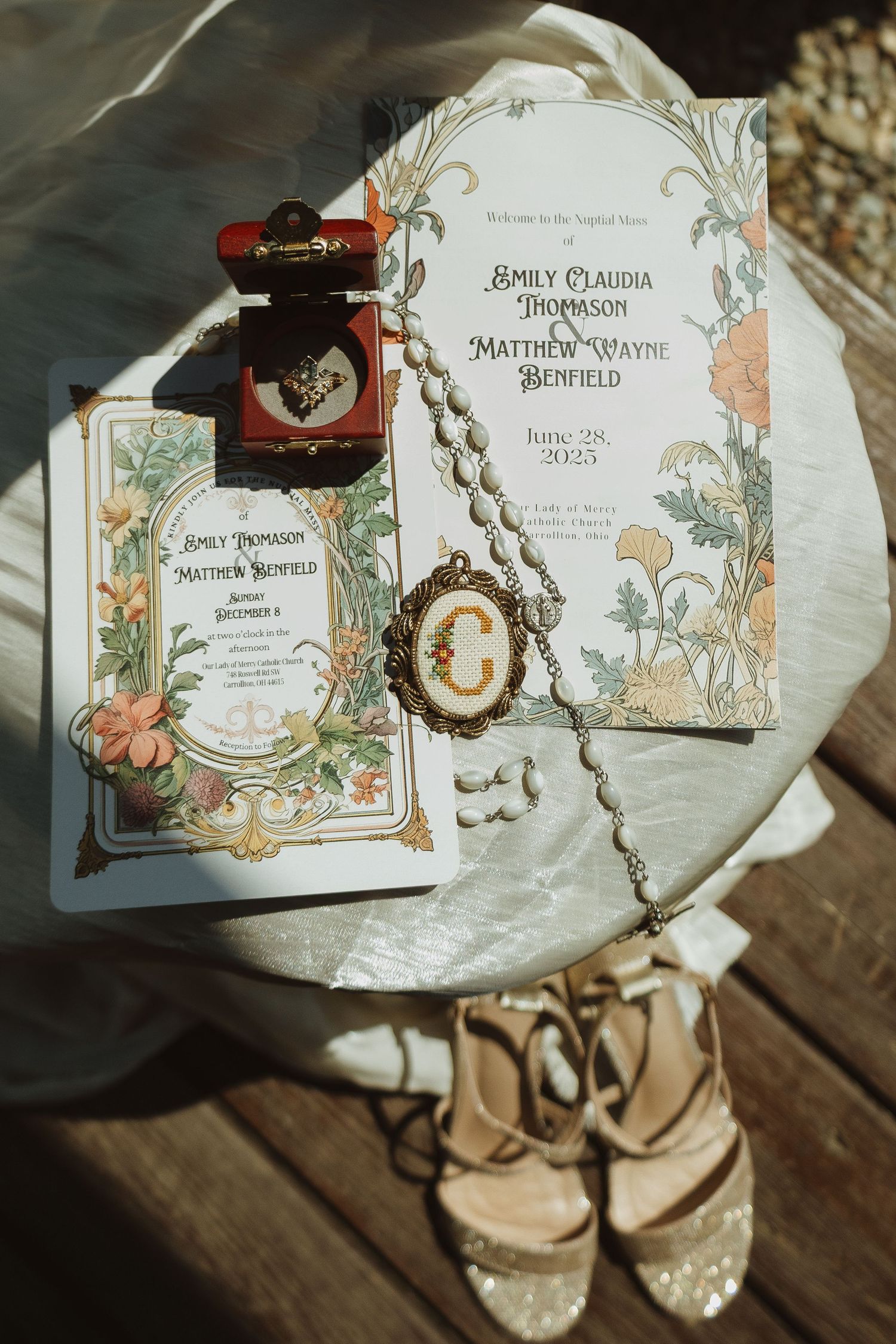 Vintage-style wedding invitation cards with floral designs and elegant calligraphy displayed on a rustic wooden surface.