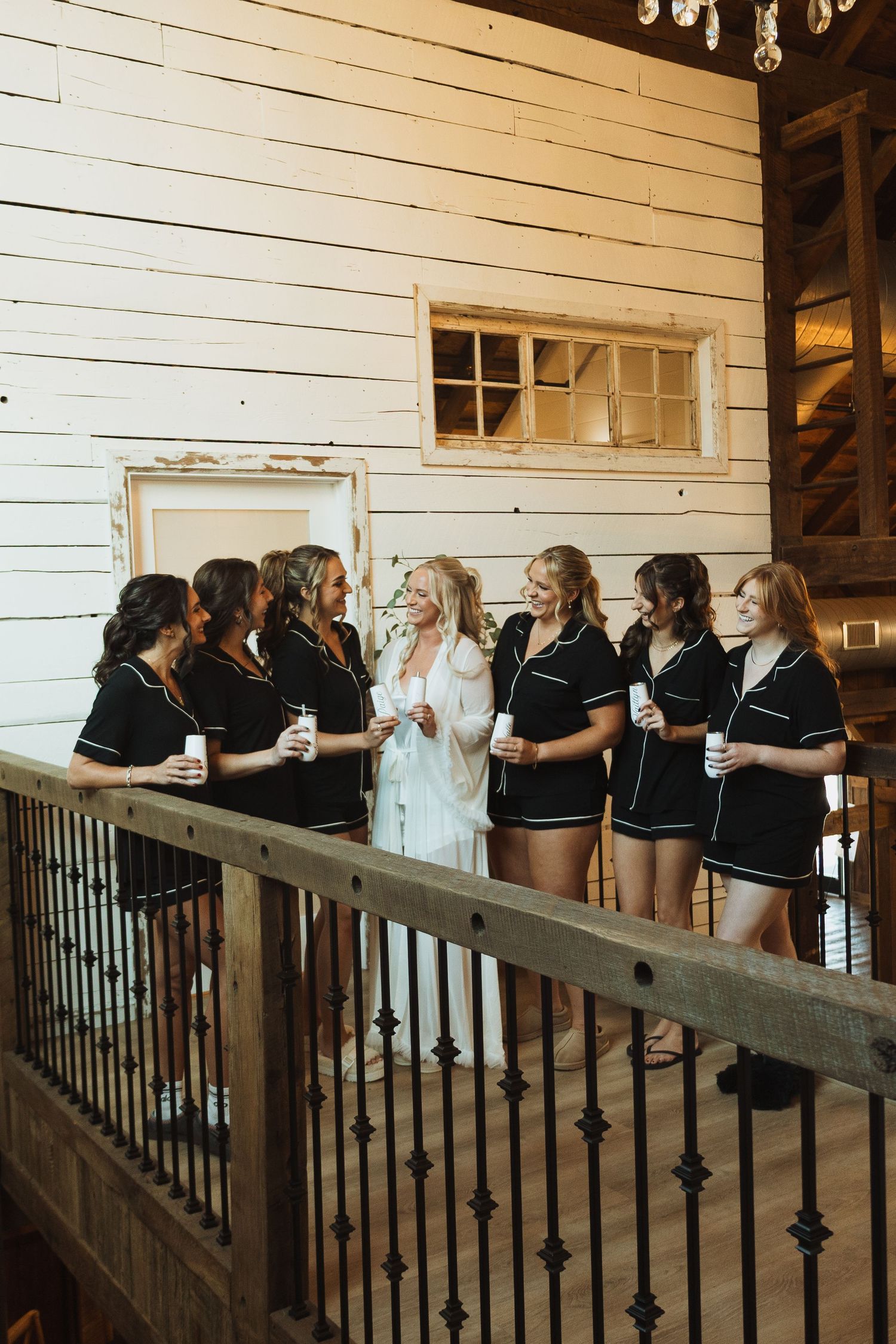 A group in matching black outfits gathers on a rustic wooden balcony.