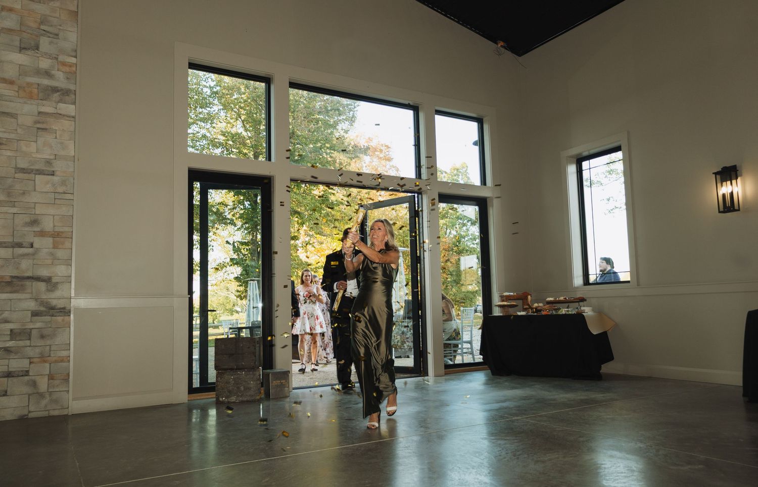 Modern event venue interior with large windows, stone accent wall and polished concrete floors.