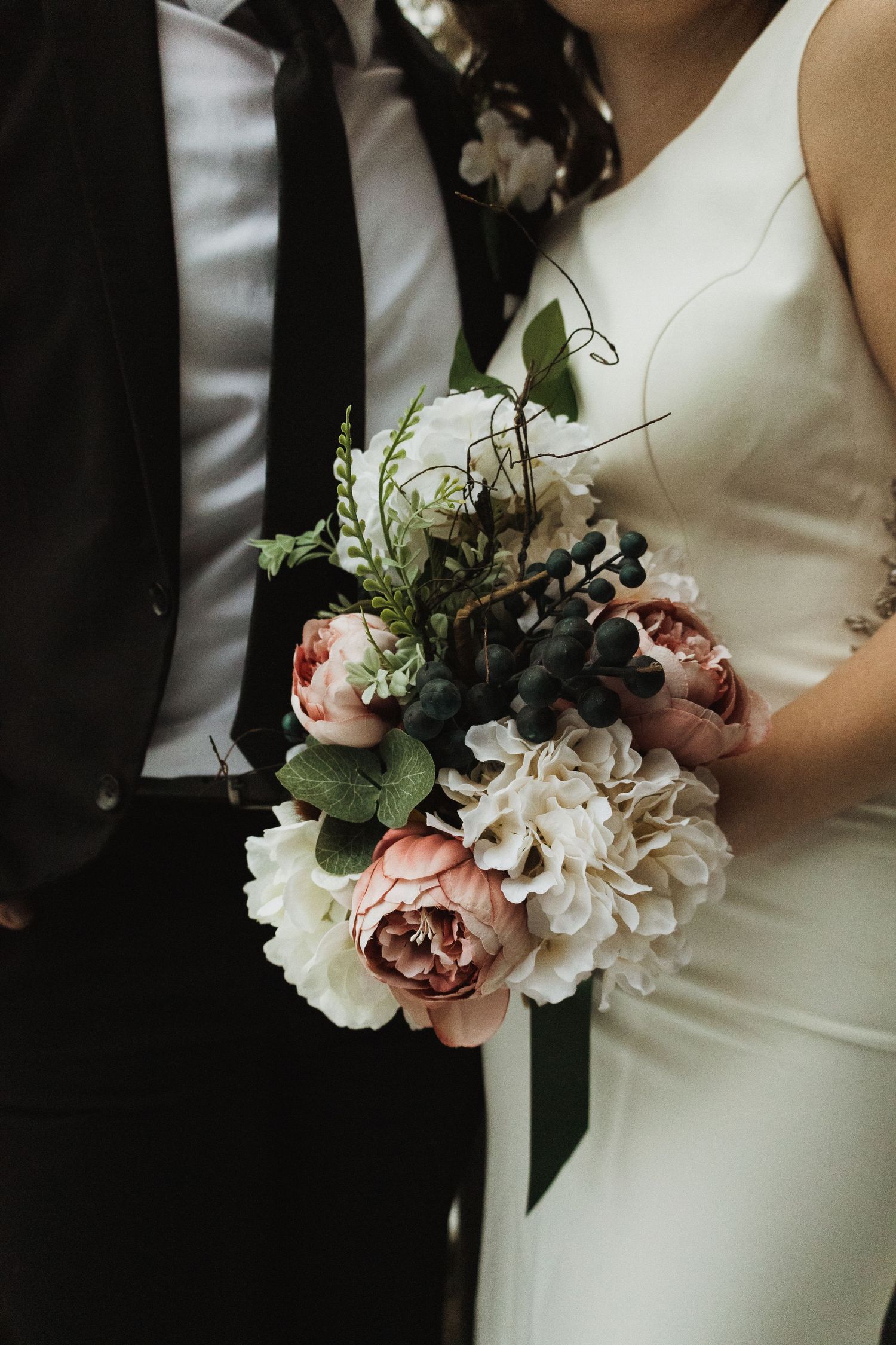 Close-up of a stunning bridal bouquet with pink peonies, white flowers, and greenery.