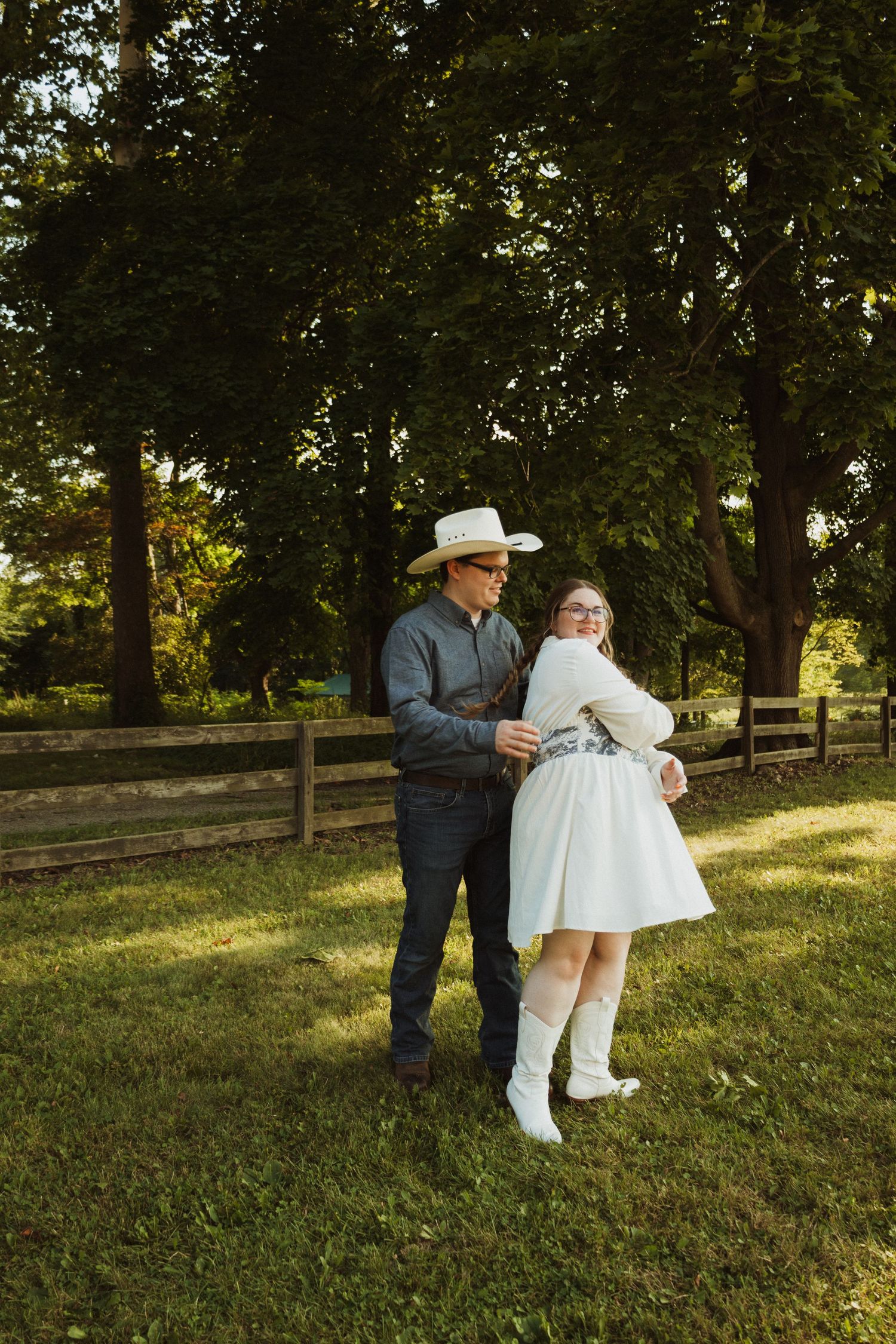 A sequence of candid moments showing two figures embracing in a sunlit park with trees and grass.