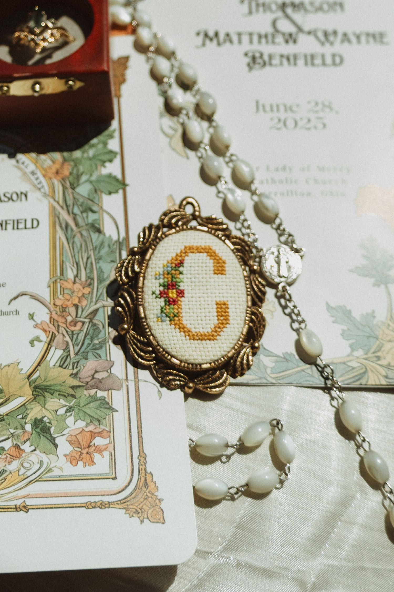 Elegant wedding invitation with pearl necklace and vintage-style decorative details.
