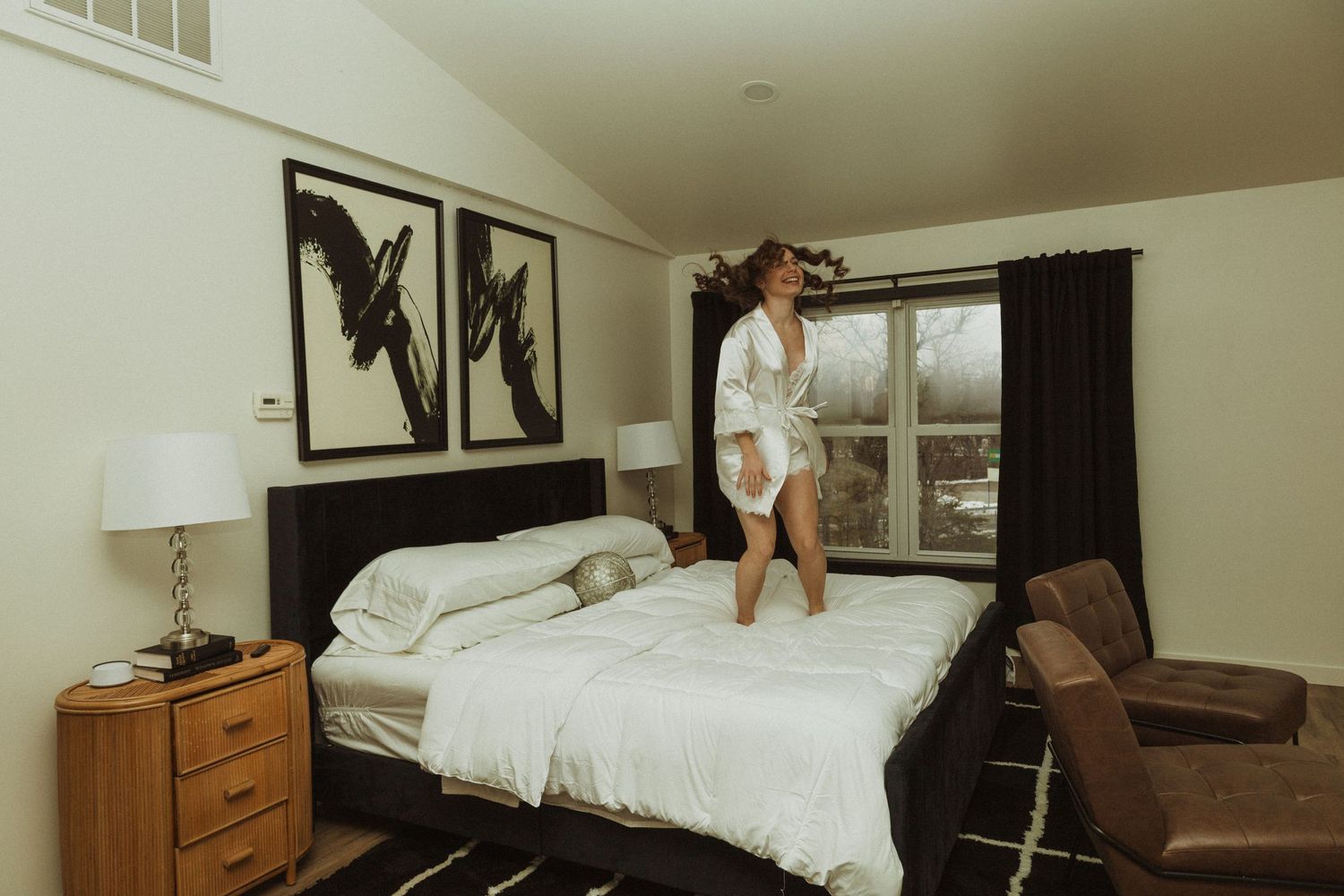 Cozy modern bedroom with black butterfly artwork, wooden nightstands, and white bedding on a stylish platform bed.