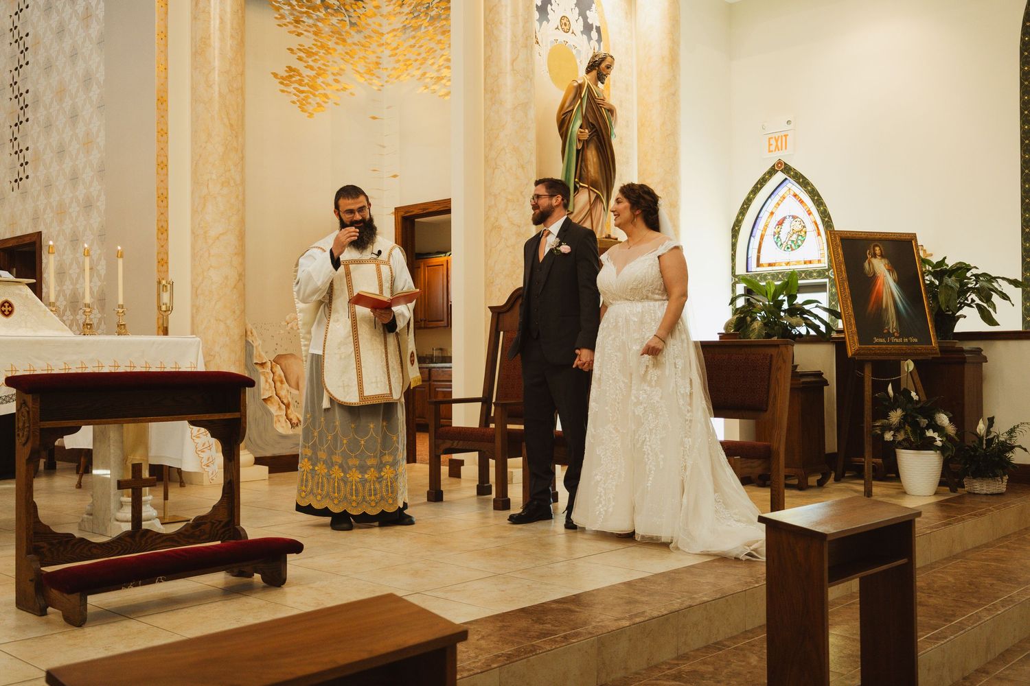 Wedding ceremony taking place in an elegant church sanctuary with ornate gold decor.