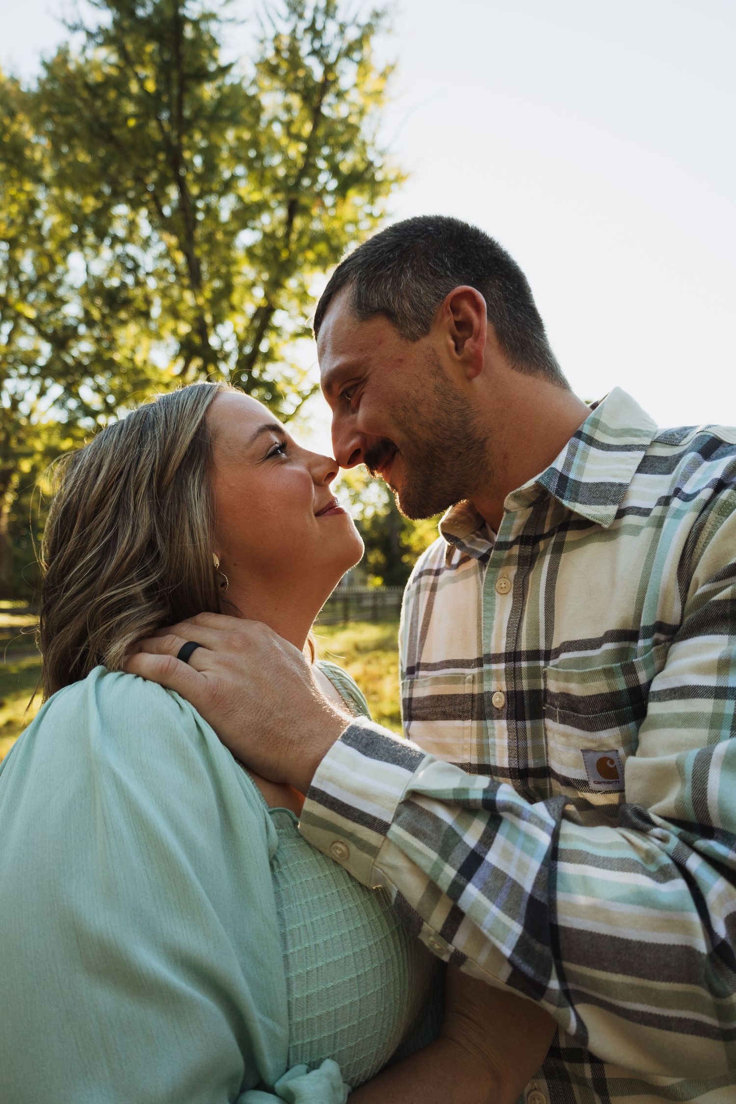 A romantic couple shares tender moments in a series of intimate outdoor portraits at sunset.