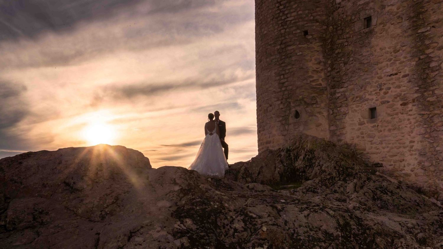 couple de mariés s'enlacent au couché de soleil