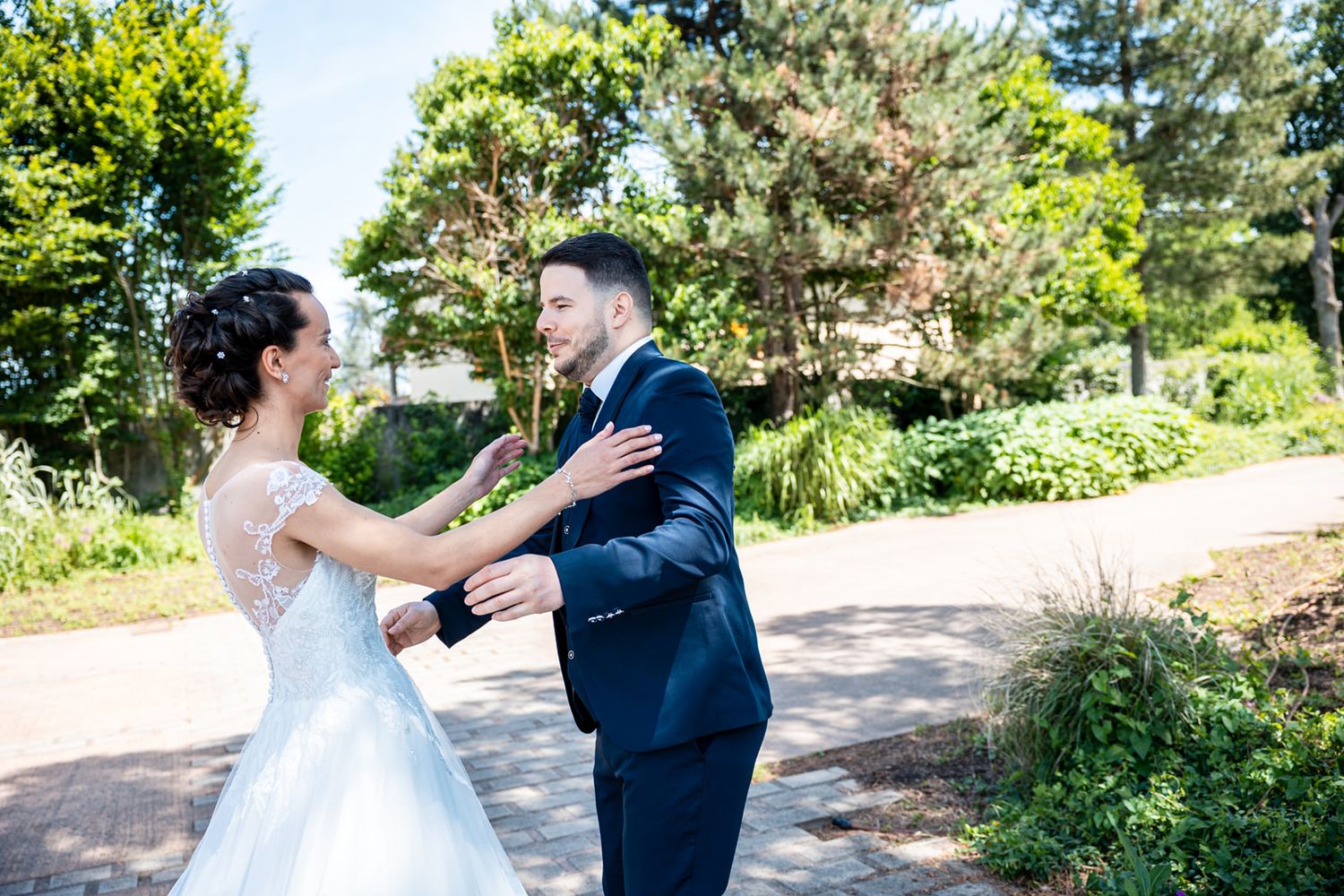 A romantic first look moment between a bride and groom in a lush garden setting during their wedding day.