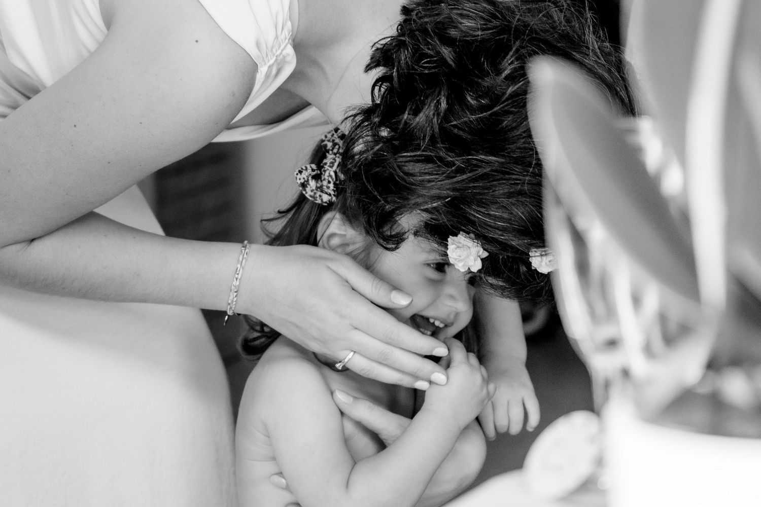 A tender black and white photograph showing a gentle moment between parent and child.