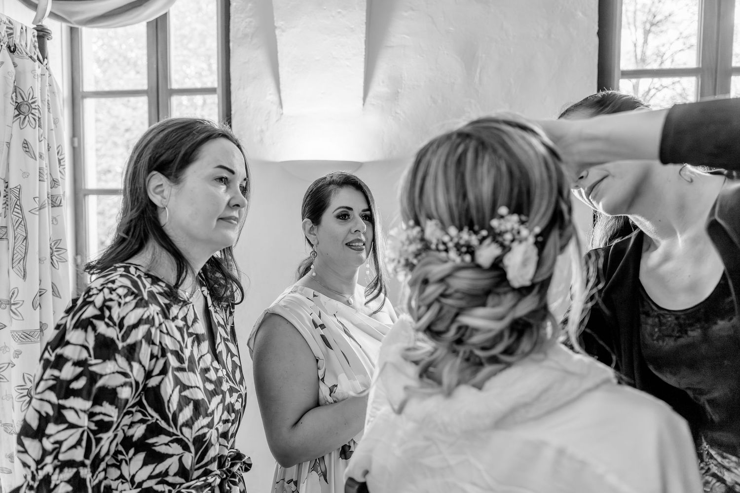 A series of black and white photos showing candid moments at a wedding celebration with guests and dancing.