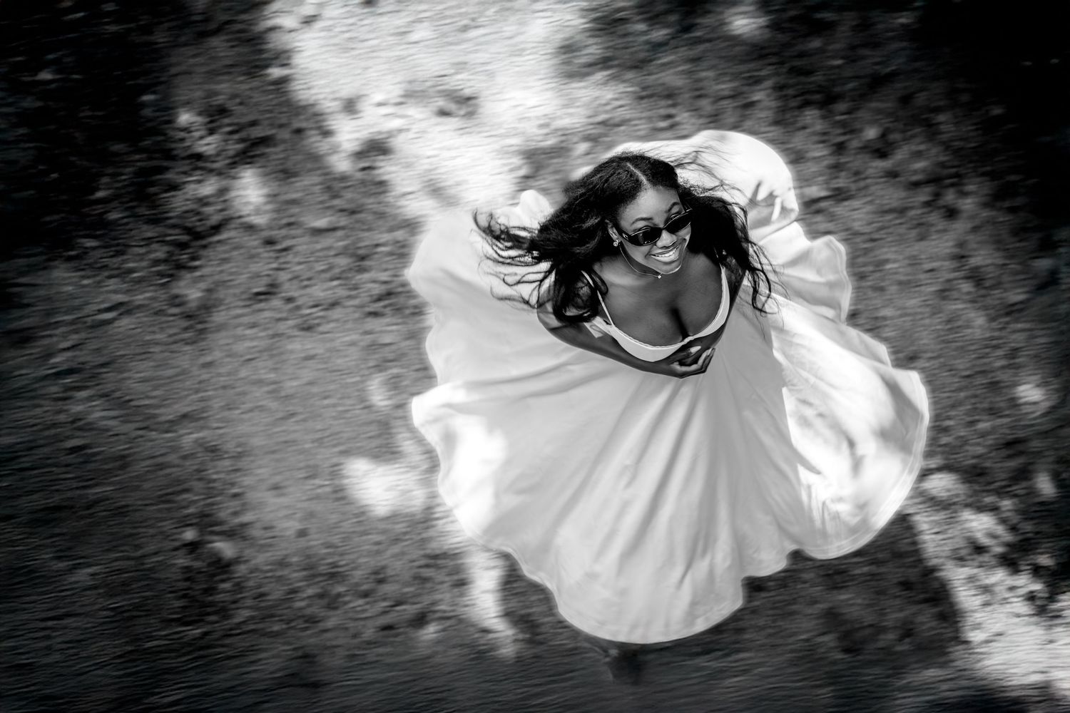 portrait femme en noir et blanc qui tourne sur elle même avec une robe blanche
