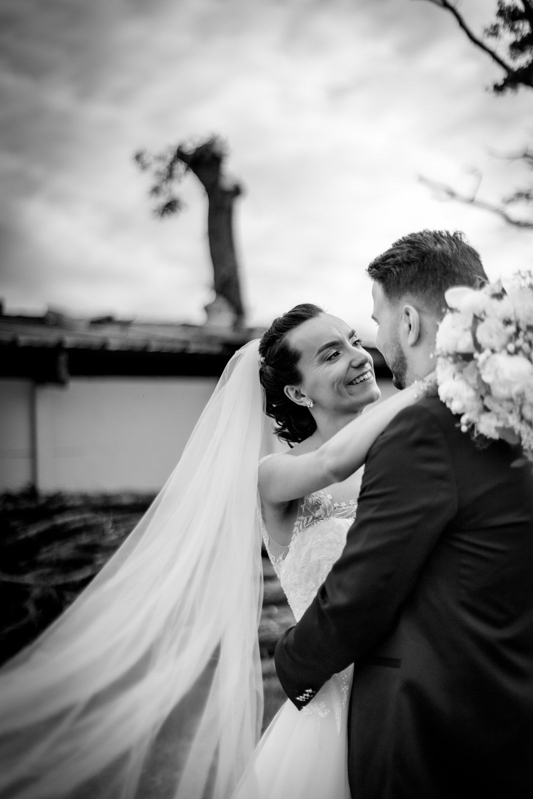 A romantic black and white photo series showing a couple sharing joyful moments on their wedding day.